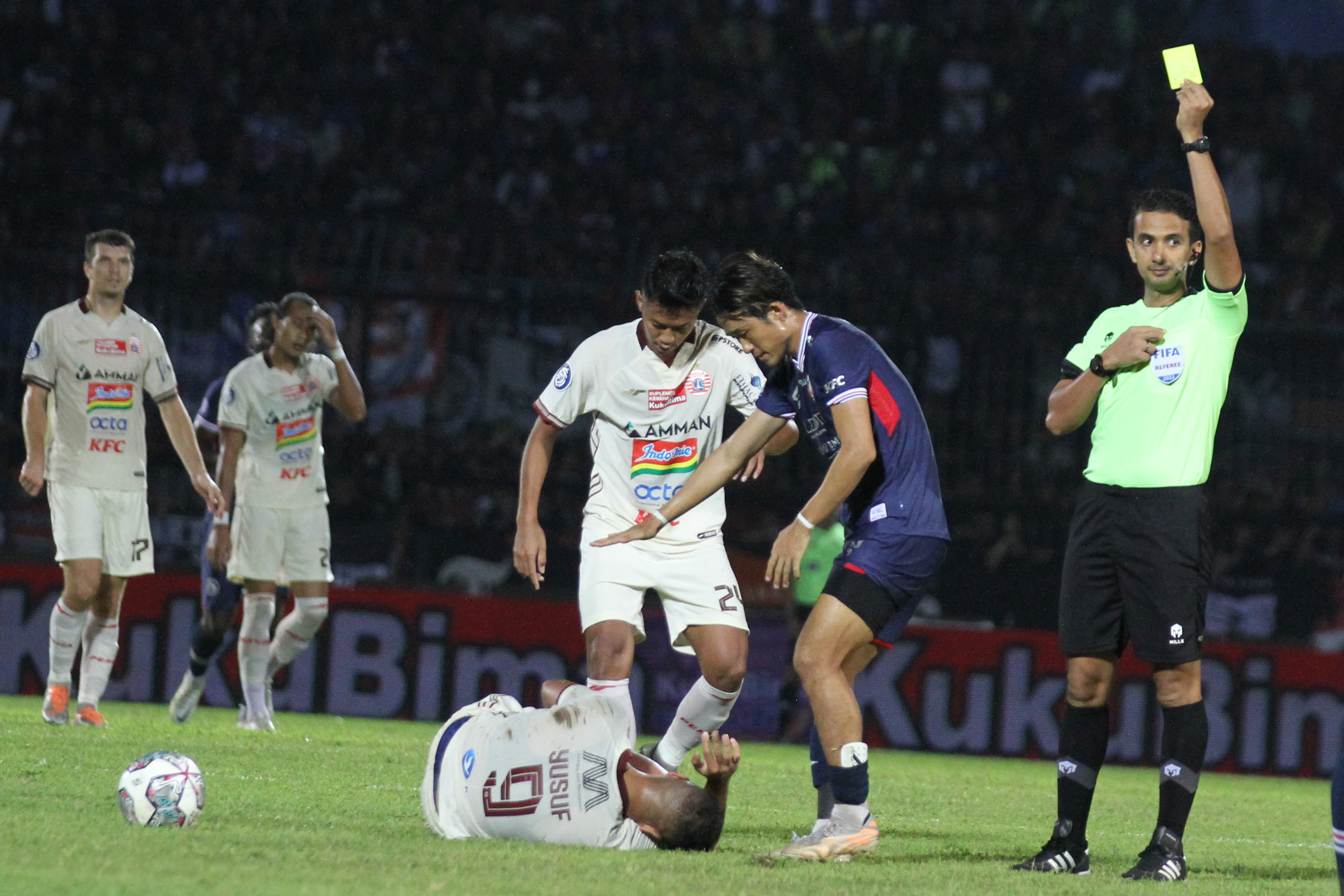 Wasit Thoriq Al Katiri (kanan) mengeluarkan kartu kuning di laga Liga 1.
