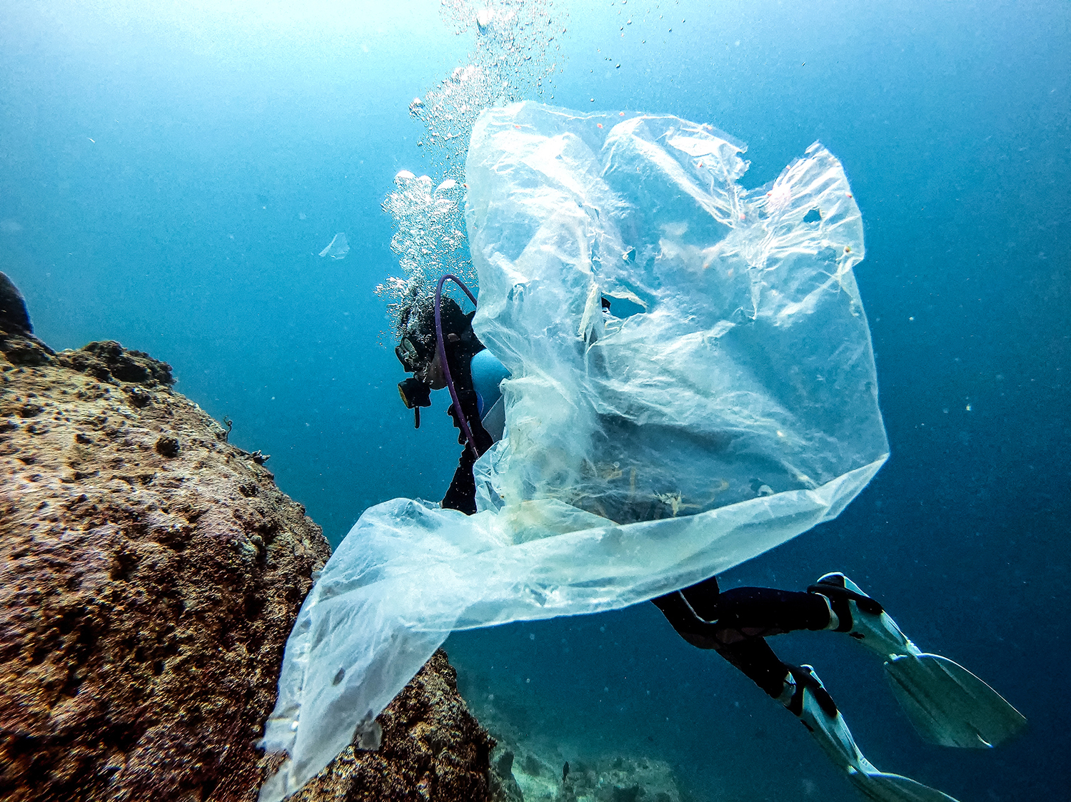 Sampah plastik putih transparan melayang-layang saat penyelam mengeksplor kedalaman laut Pulau Weh, Aceh (28/02/2021).