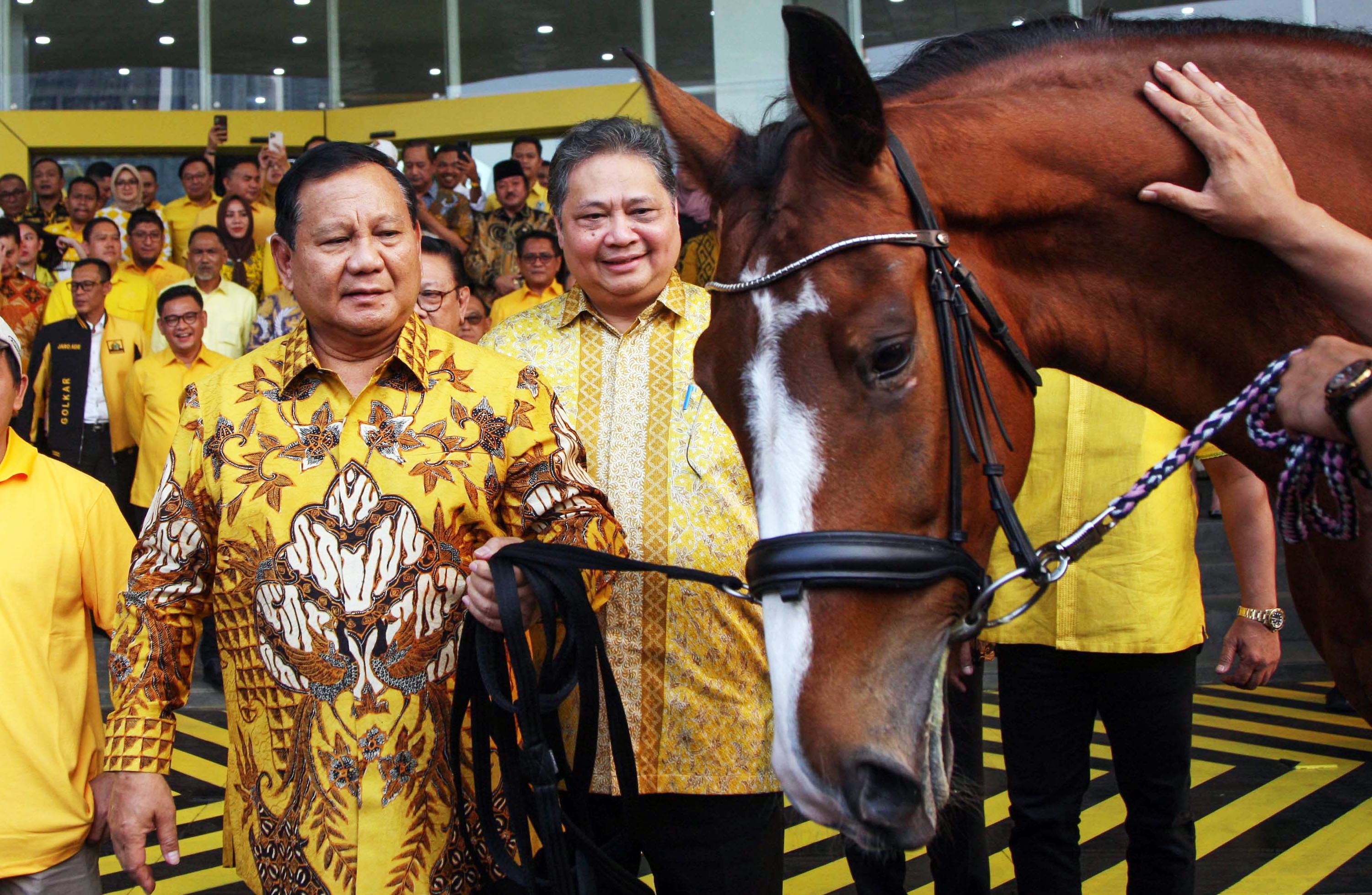 akal calon presiden dari Koalisi Indonesia Maju, Prabowo Subianto (kedua kiri) menerima hadiah kuda Jantan dari Ketua Umum Partai Golkar