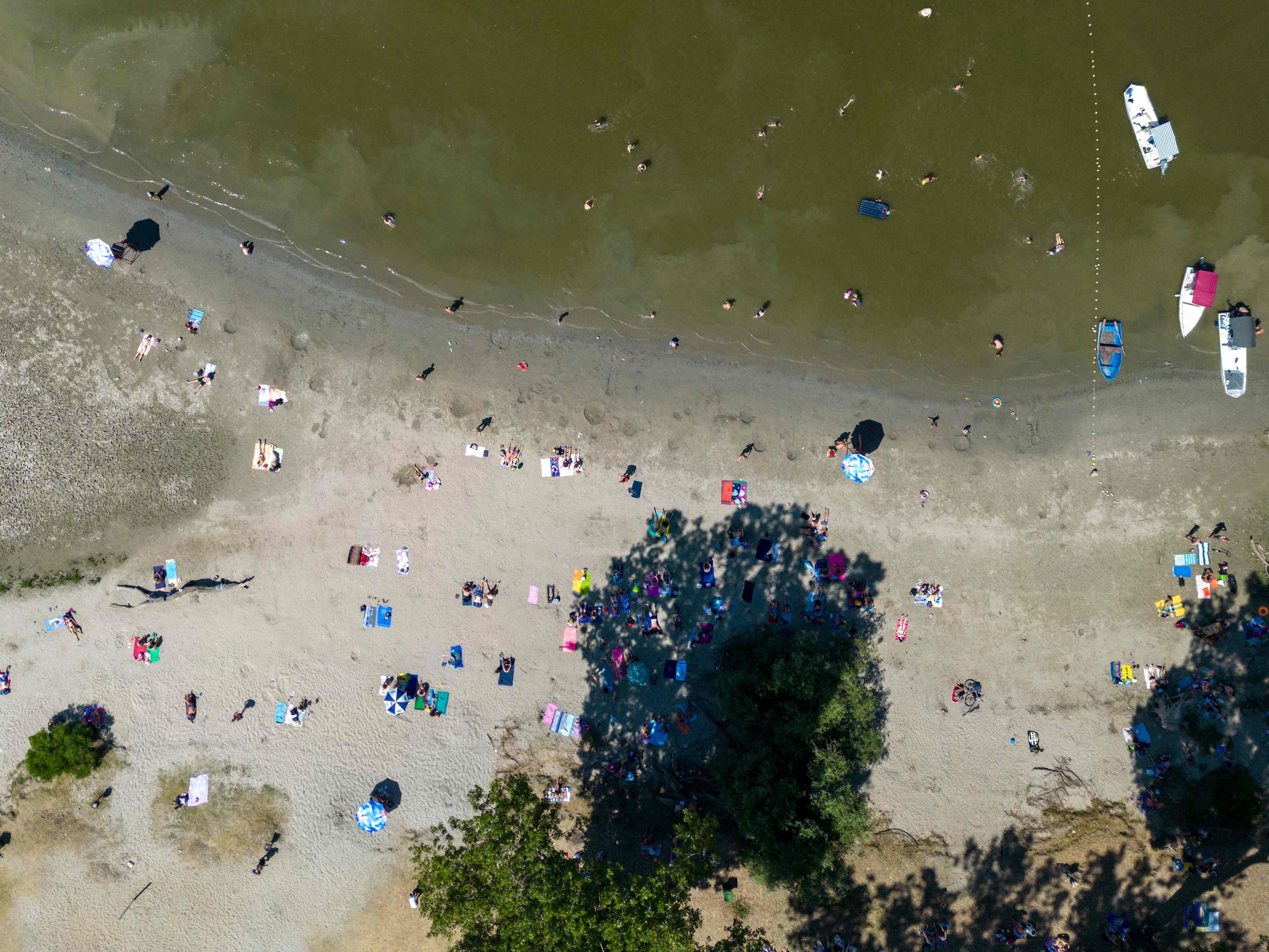 Pemandangan dari udara ini menunjukkan orang-orang melakukan pendinginan di tepi sungai Danube di Beograd, pada 15 Juli 2023.