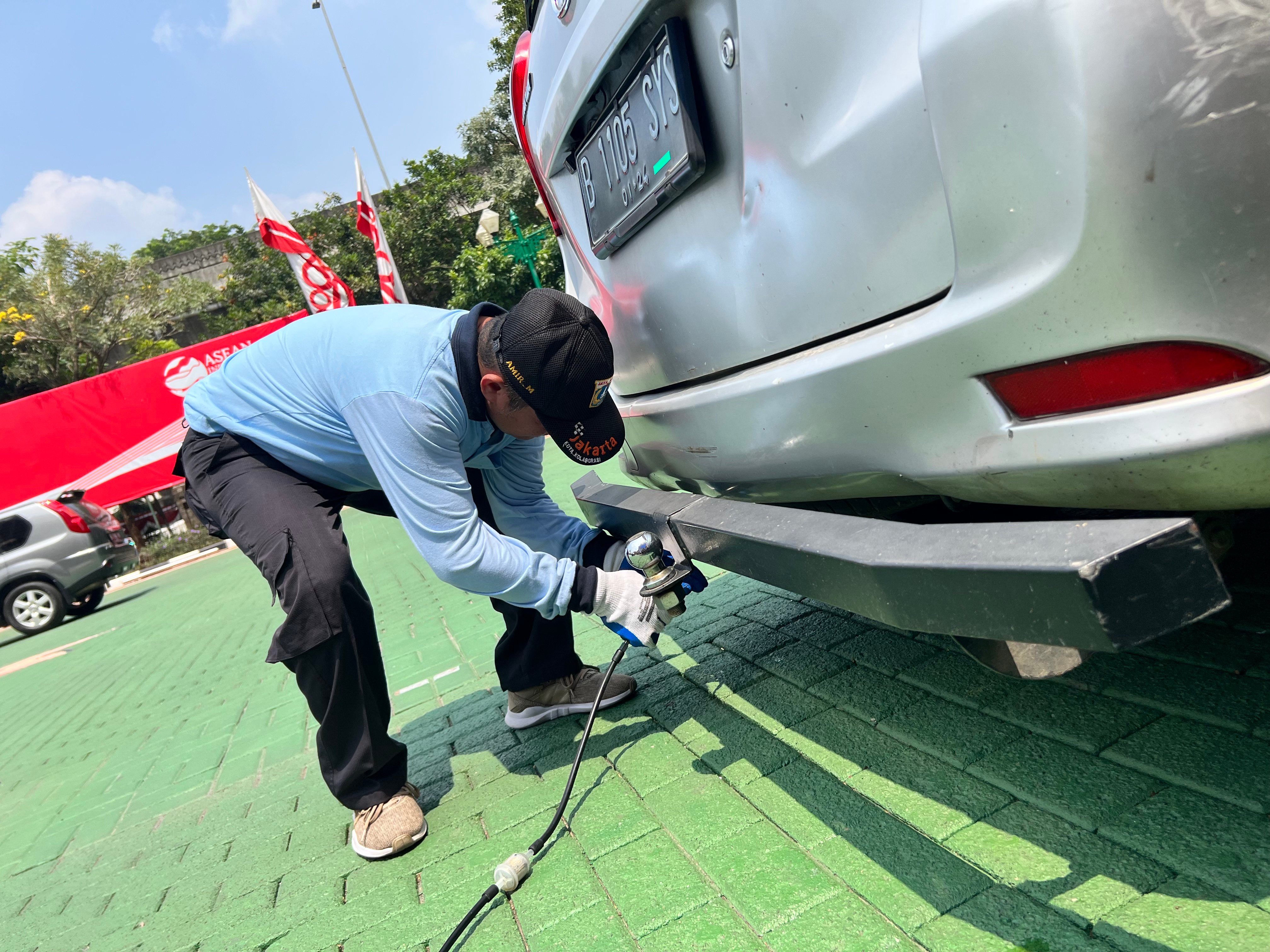 Petugas sedang melakukan uji emisi kendaraan roda empat. 
