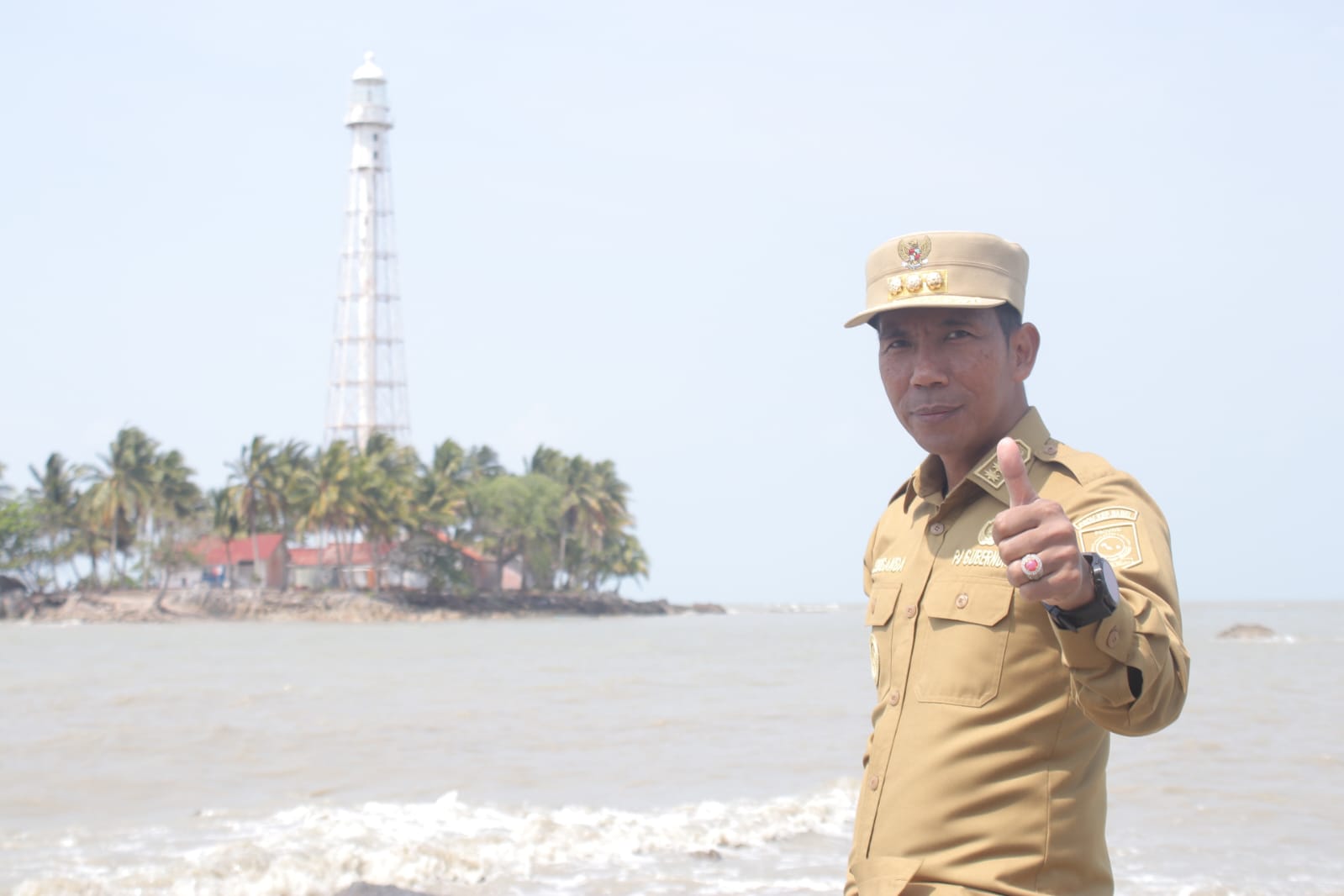 PJ Gubernur Bangka Belitung berfoto dengan latar belakang mercusuar di Pulau Besar.