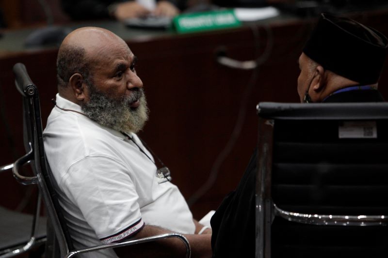 erdakwa Lukas Enembe (kiri) berdiskusi dengan penasihat hukum saat menjalani persidangan.