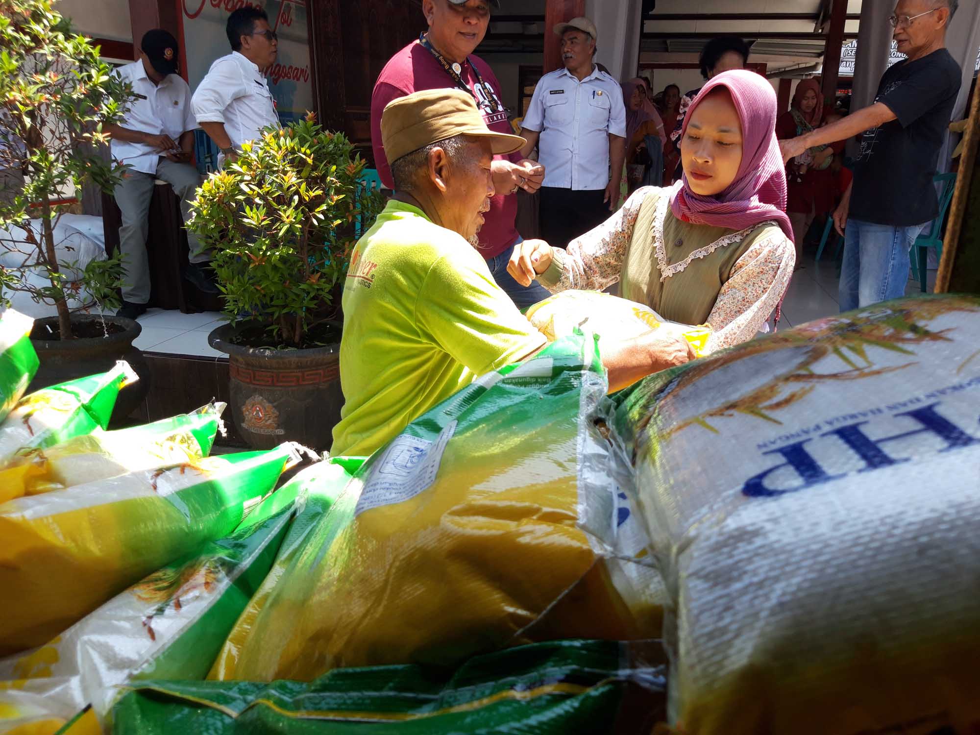 Warga membeli beras saat pasar murah beras medium program Stabilisasi Pasokan dan Harga Pangan Bulog Malang di Kantor Kecamatan Singosari.
