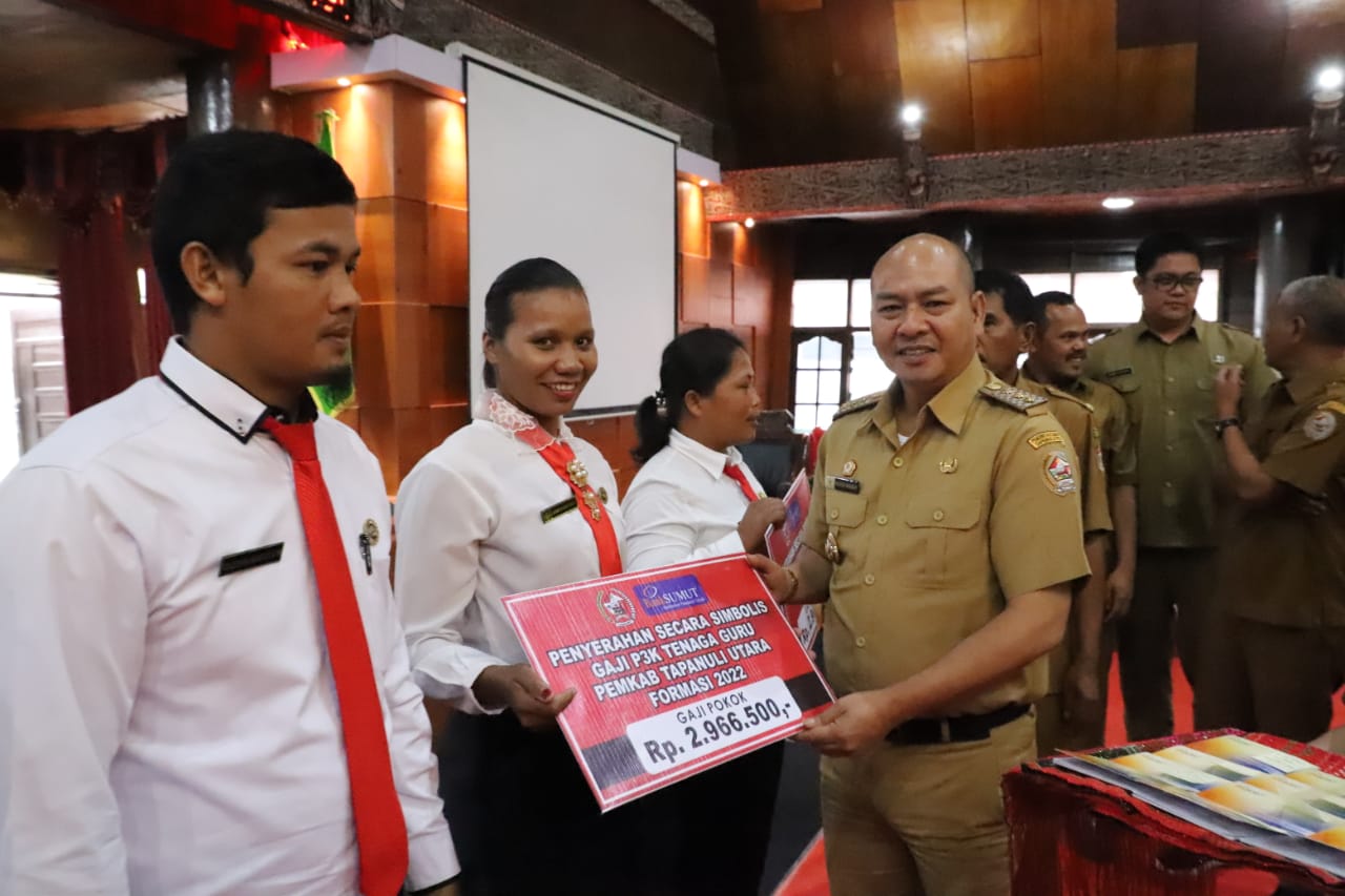 Nikson Nababan, Bupati Tapanuli Utara, saat menyerahkan gaji PPPK secara simbolis di Sopo Partungkoan Tarutung.