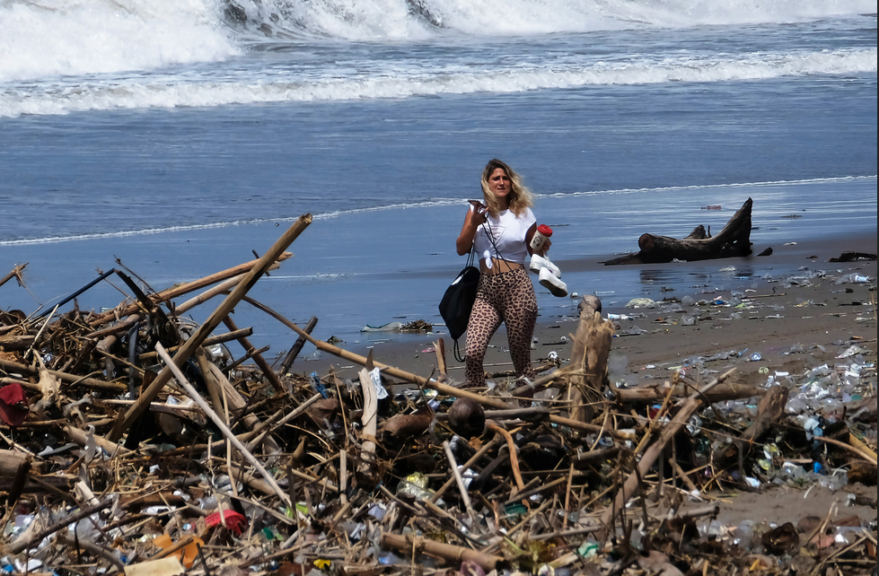 Seorang wisatawan melintas di dekat tumpukan sampah yang berserakan di sepanjang Pantai Berawa, Kuta Utara, Badung, Bali.