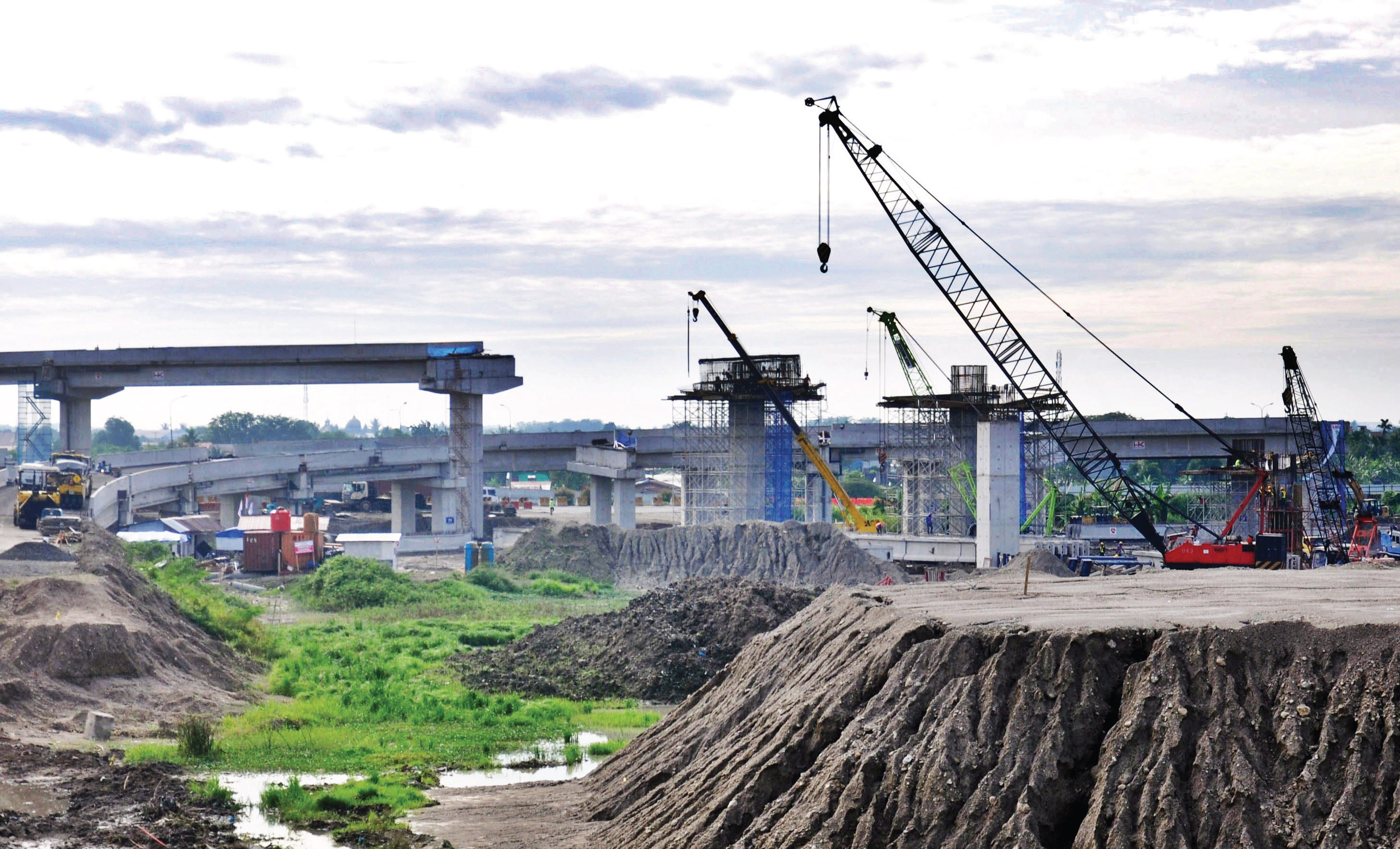 Pekerja menggunakan alat berat untuk menyelesaikan ruas tol di Gerbang Tol Tanjung Mulia Medan, Sumatra Utara, Rabu (29/7/2020).