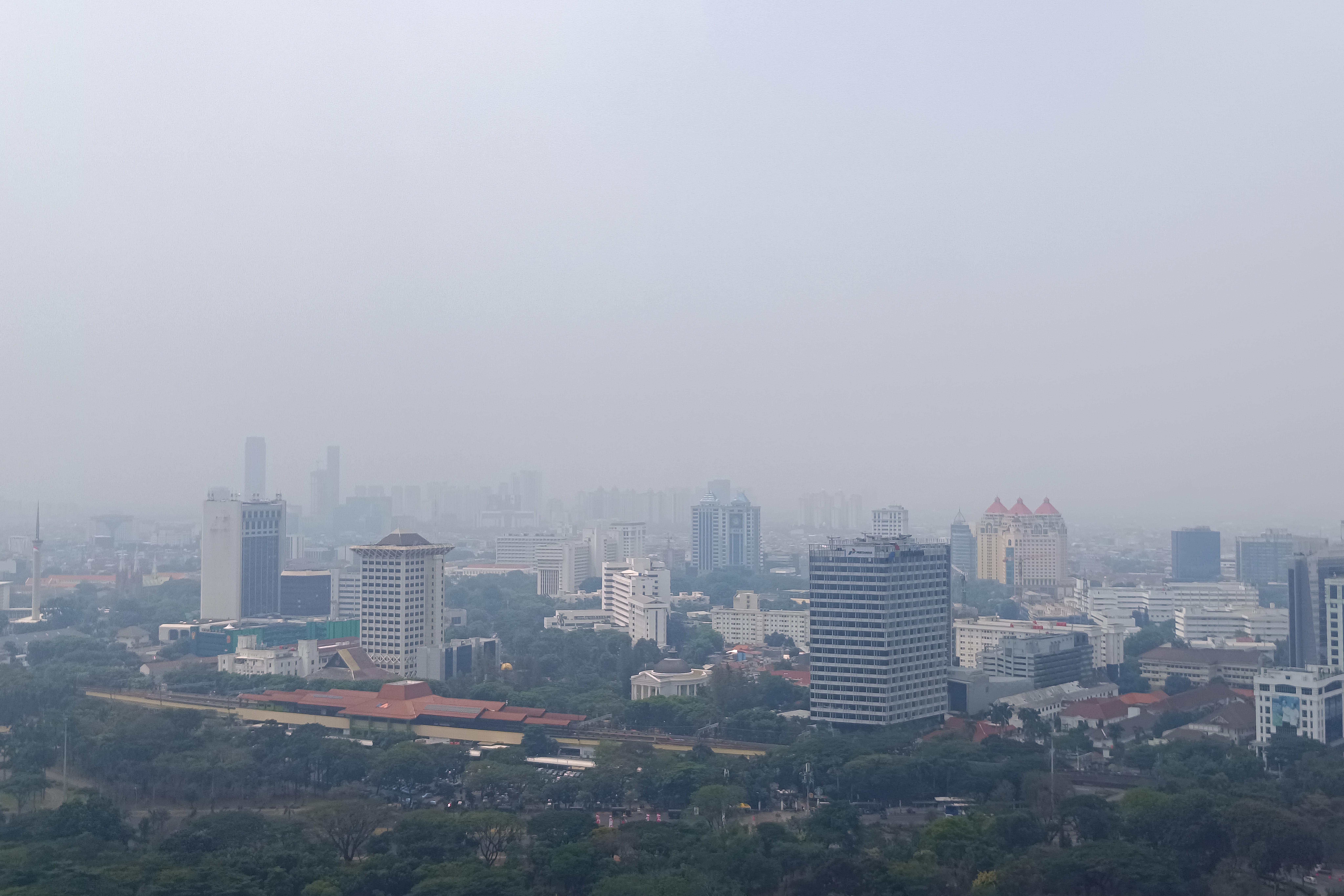 Gedung bertingkat terlihat samar karena polusi udara di Jakarta, Minggu (2/9).
