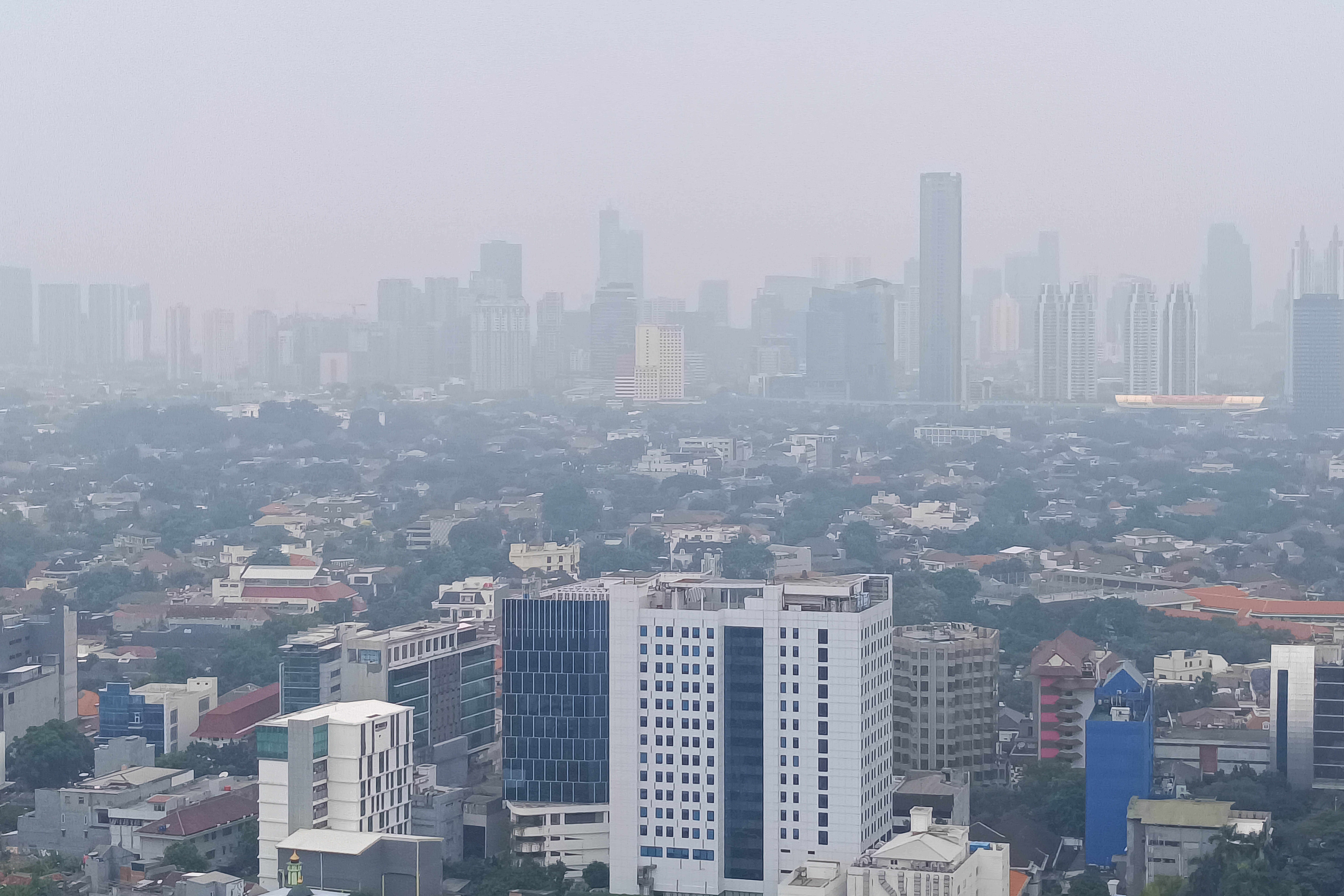 Gedung bertingkat terlihat samar karena polusi udara di Jakarta, Minggu (2/9). 