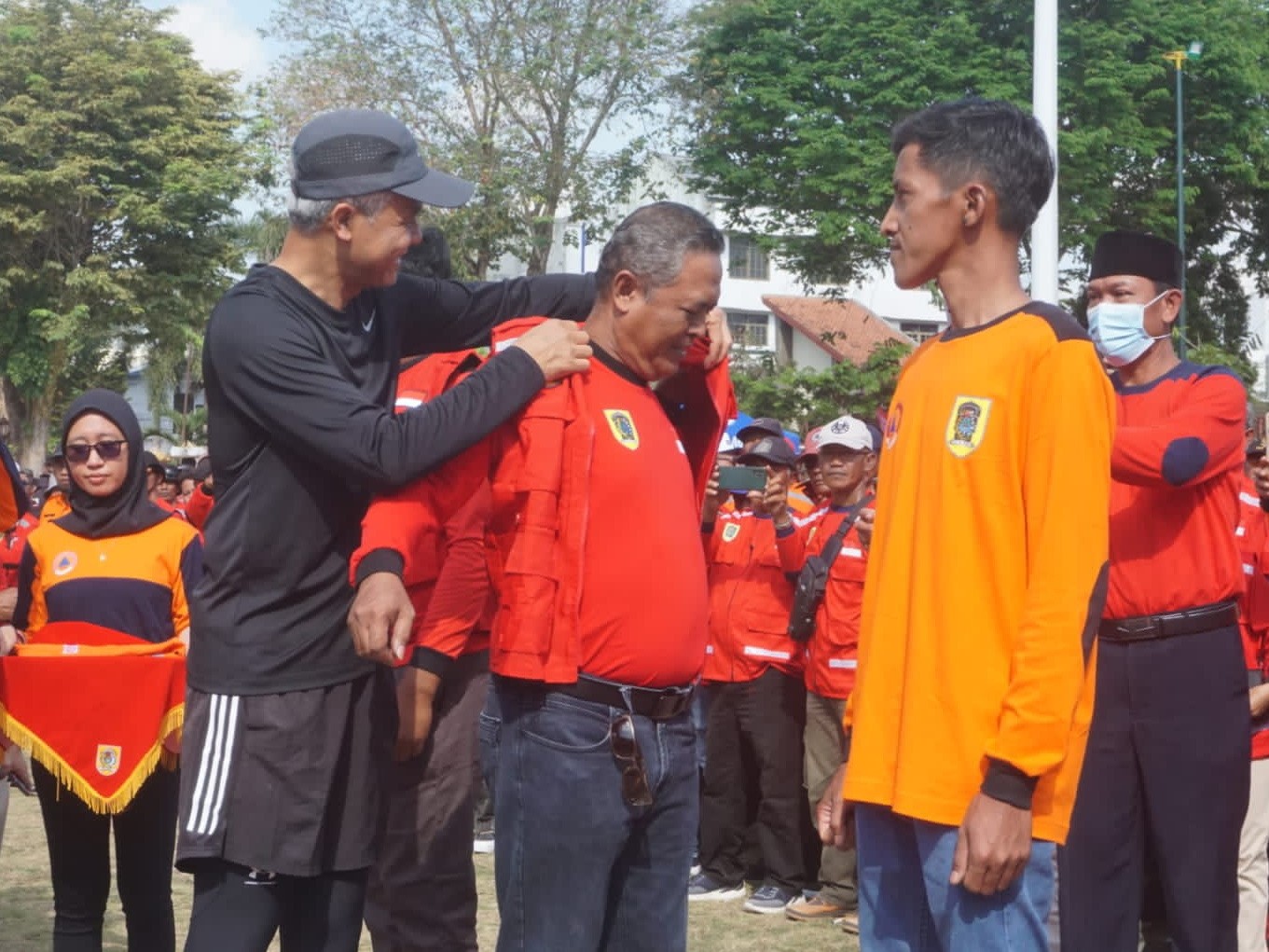 Gubernur Ganjar Pranowo memakaikan rompi pada relawan kebencanaan.