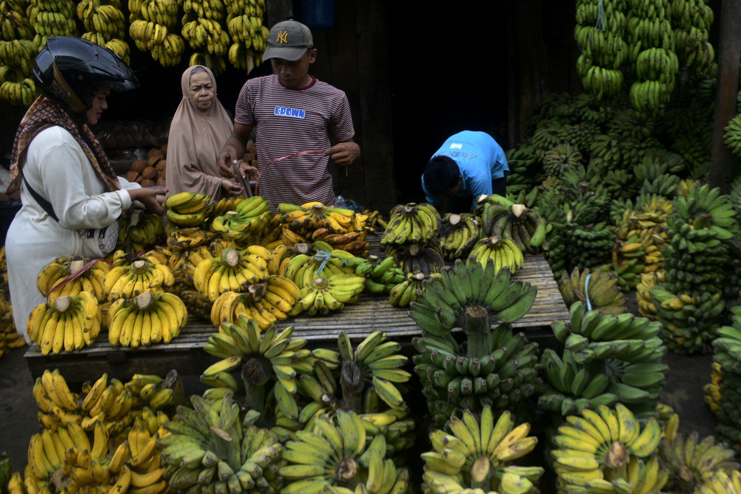 Pedagang buah pisang melayani pembeli di Pasar Terong, Makassar, Sulawesi Selatan, Rabu (25/1).