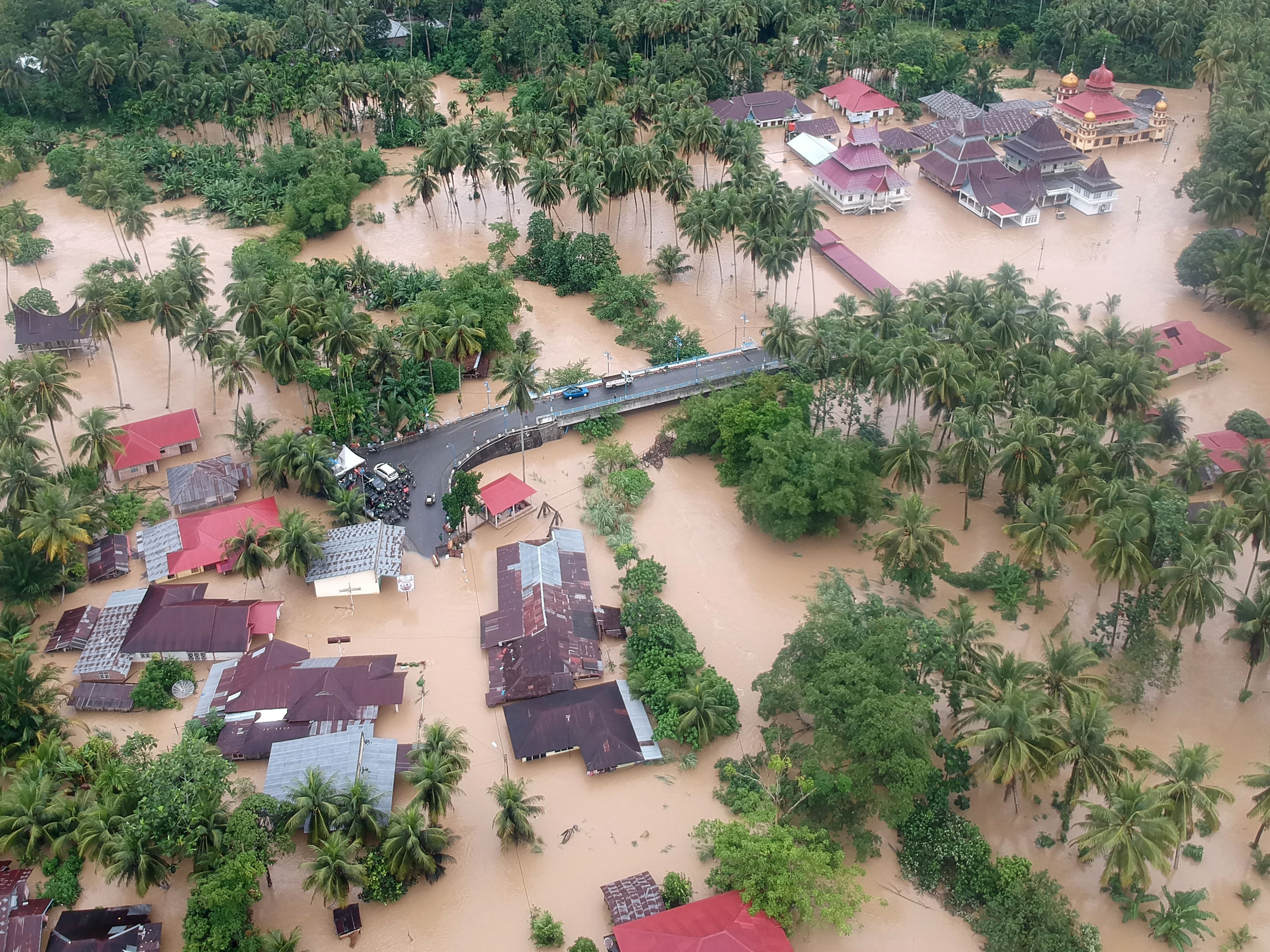 Warga terjebak di atas jembatan yang terendam banjir di Nagari Kampung Galapuang, Ulakan Tapakis, Padang Pariaman, Sumbar, Mei lalu.