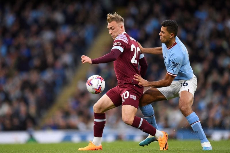 Striker West Ham Jarrod Bowen dan gelandang Manchester City Rodri berduel memperebutkan bola.