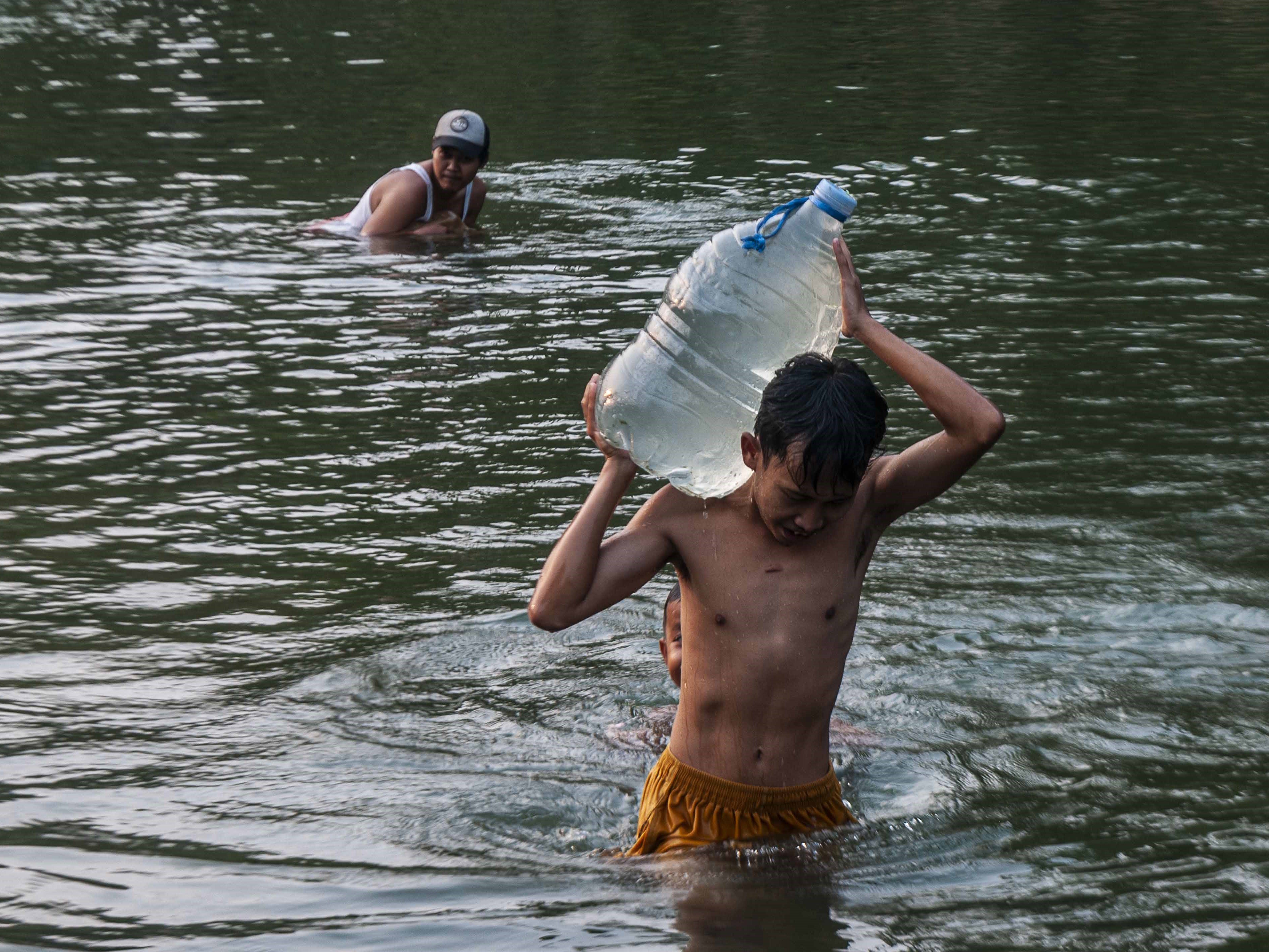 Seorang anak membawa galon berisi air dari Sungai Ciberang di Desa Bungur Mekar, Lebak, Banten, Minggu (3/8/2023).