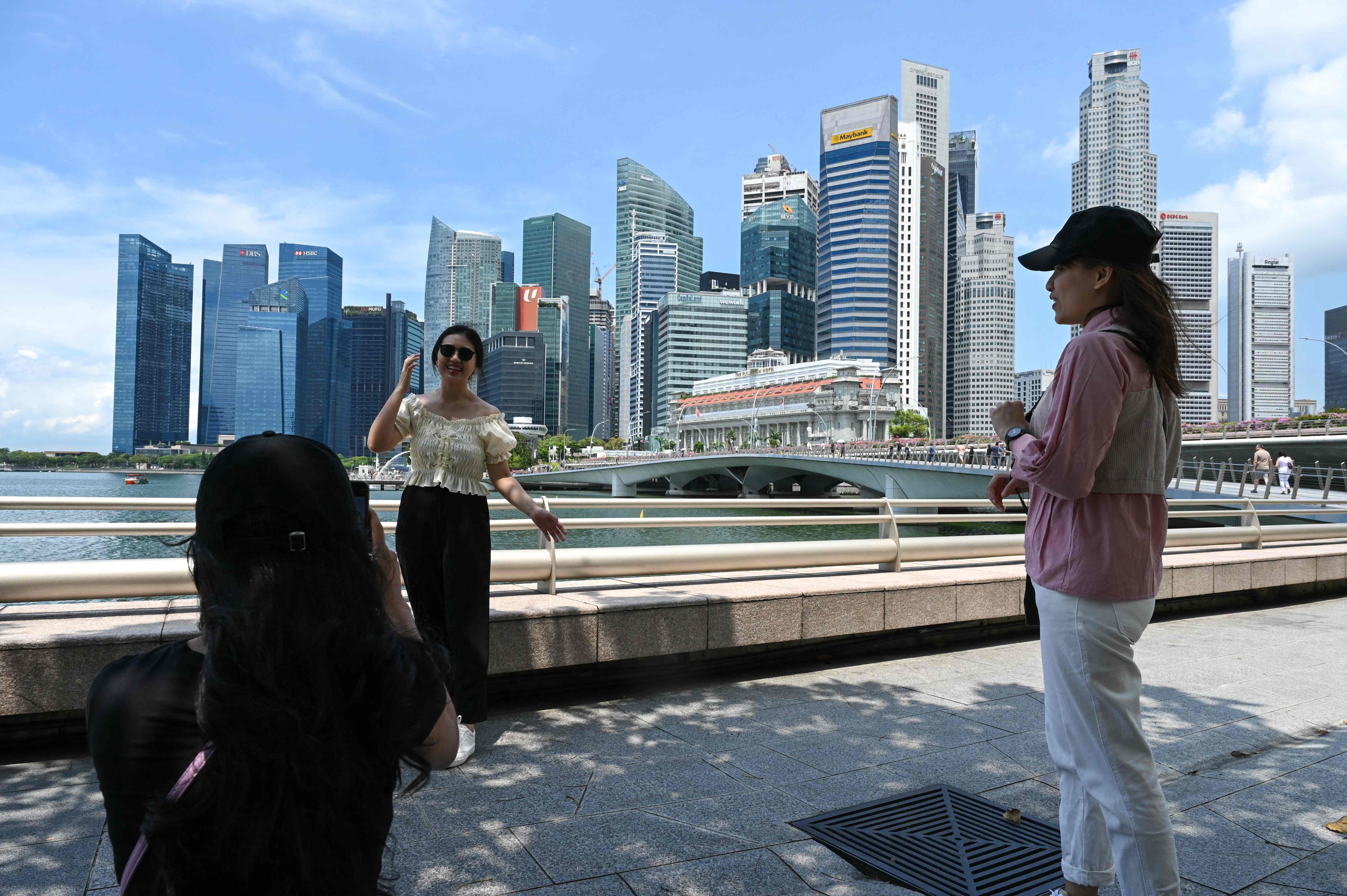 Masyarakat berfoto dengan latar belakang Kota Singapura