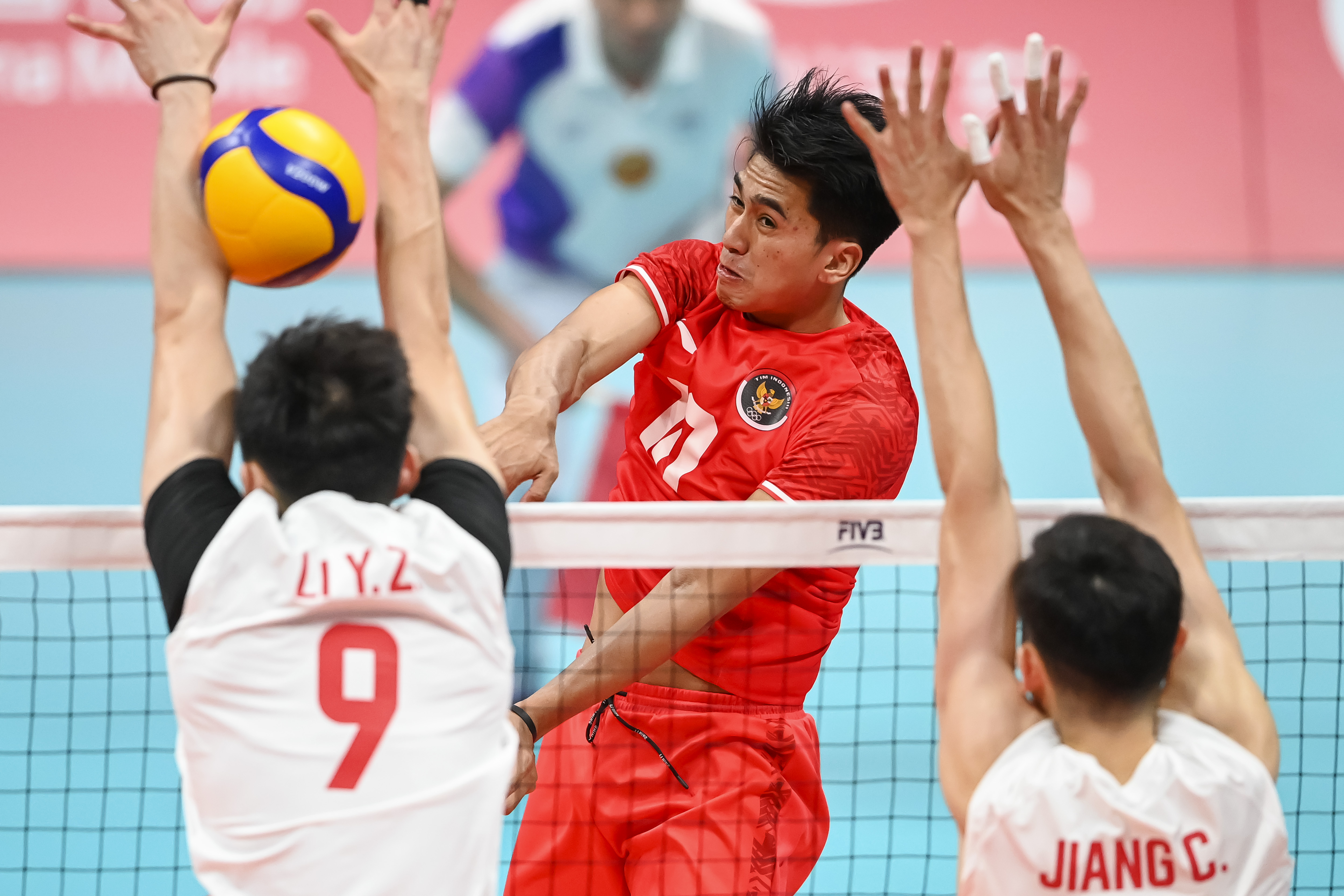 Pebola voli putra Indonesia Fahri Septian Putratama (tengah) melakukan spike di laga Asian Games melawan Tiongkok.