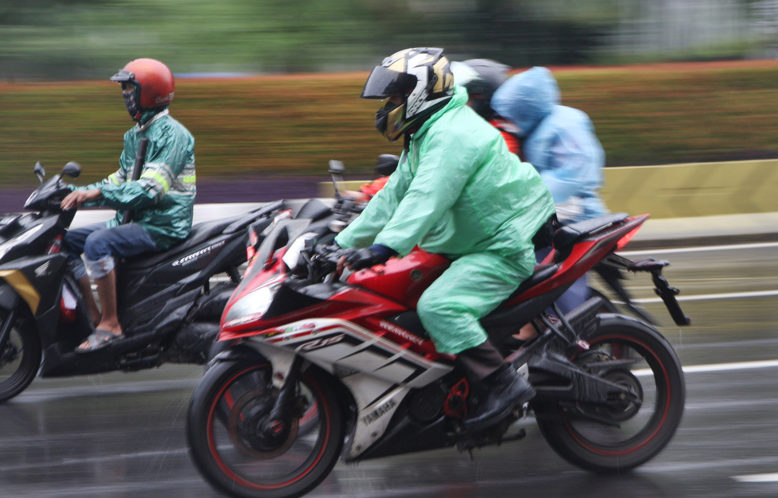 Pengendara motor melintas saat hujan turun di kawasan Matraman, Jakarta.