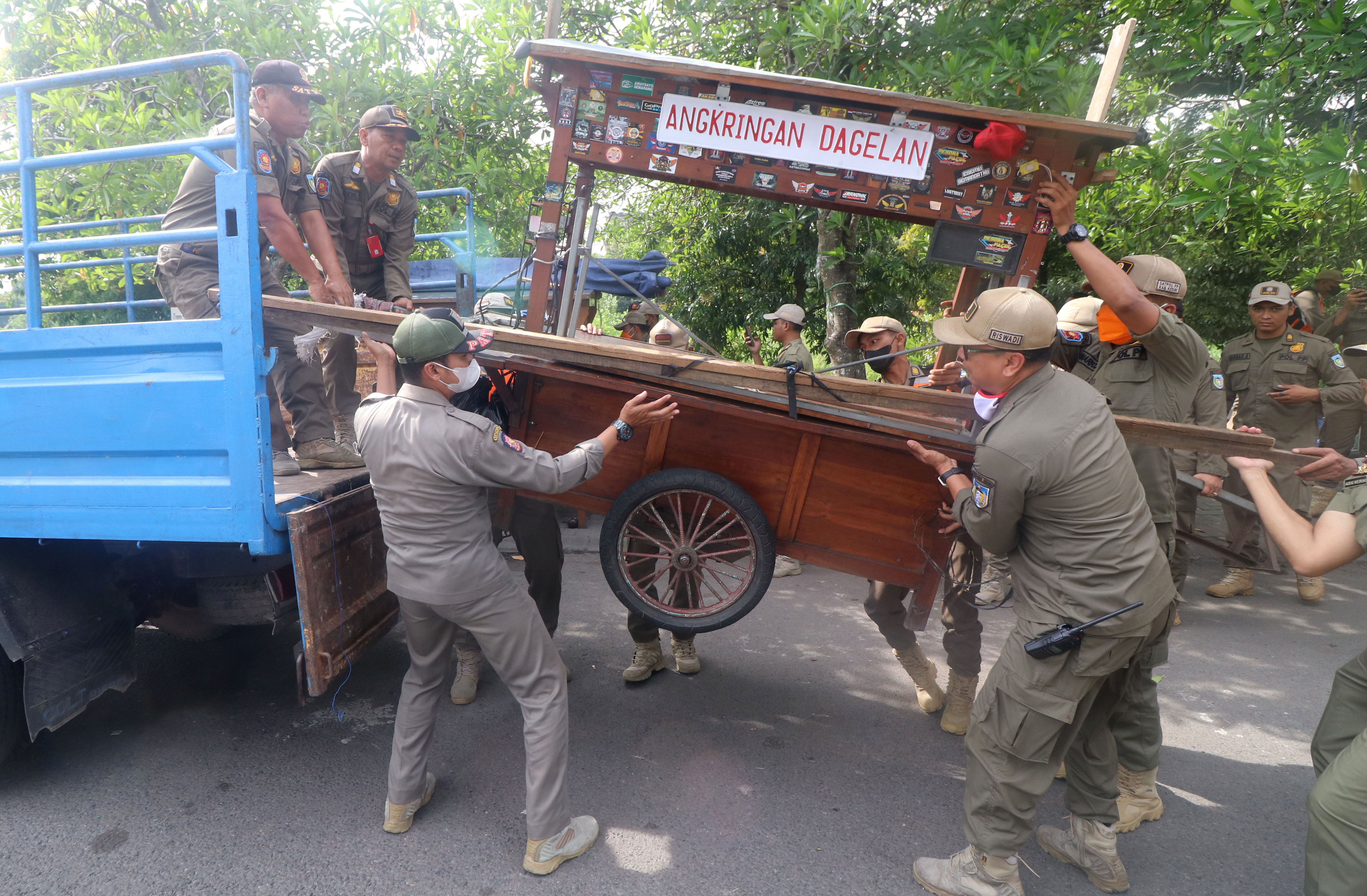 Ilustrasi: Satpol PP mengangkut gerobak milik PKL ke bak truk saat penertiban di Simpang Lima Gumul (SLG) Kediri, Jatim, Selasa (9/5/2023).