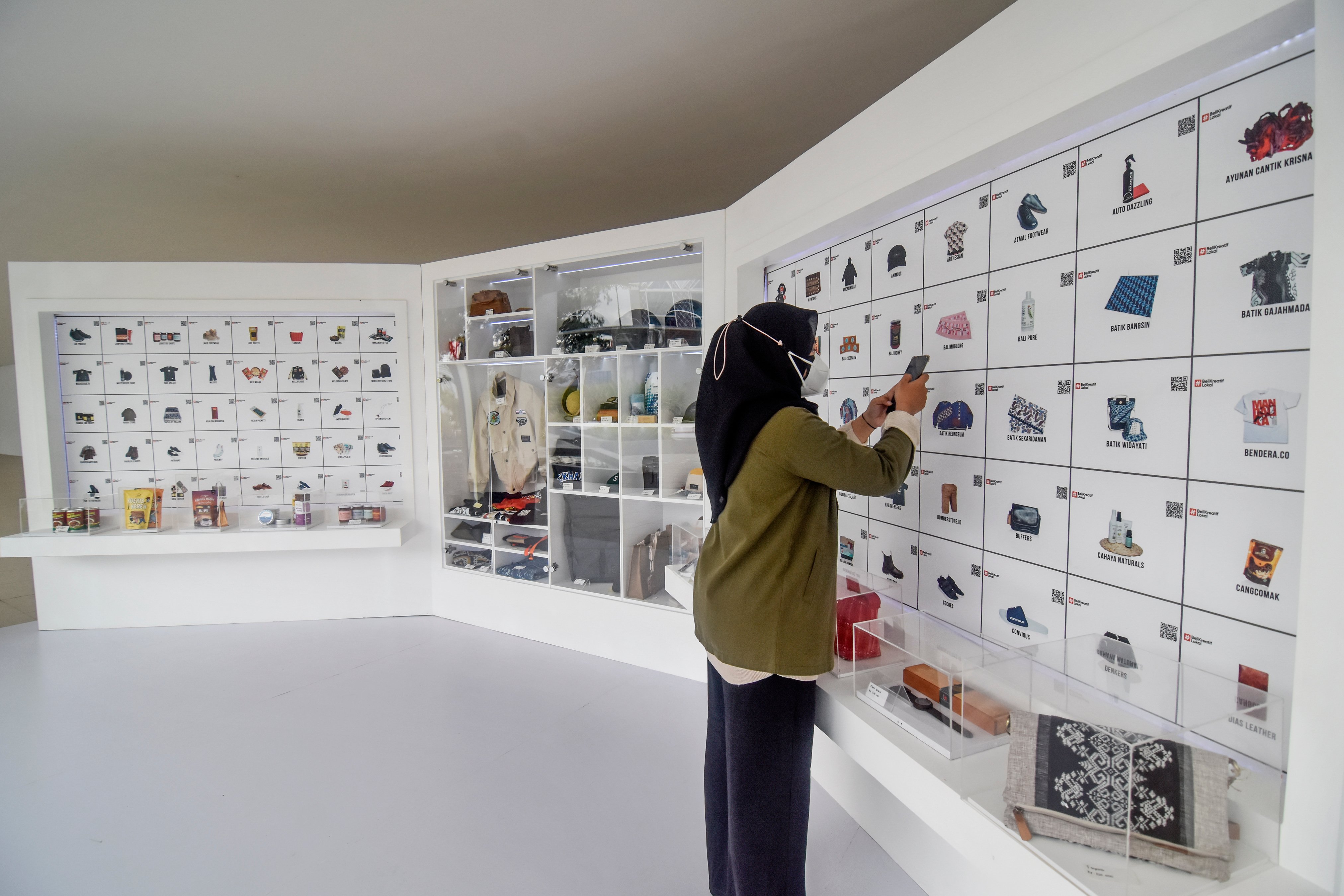 Ilustrasi. Warga memindai QR code planogram digital produk UMKM.