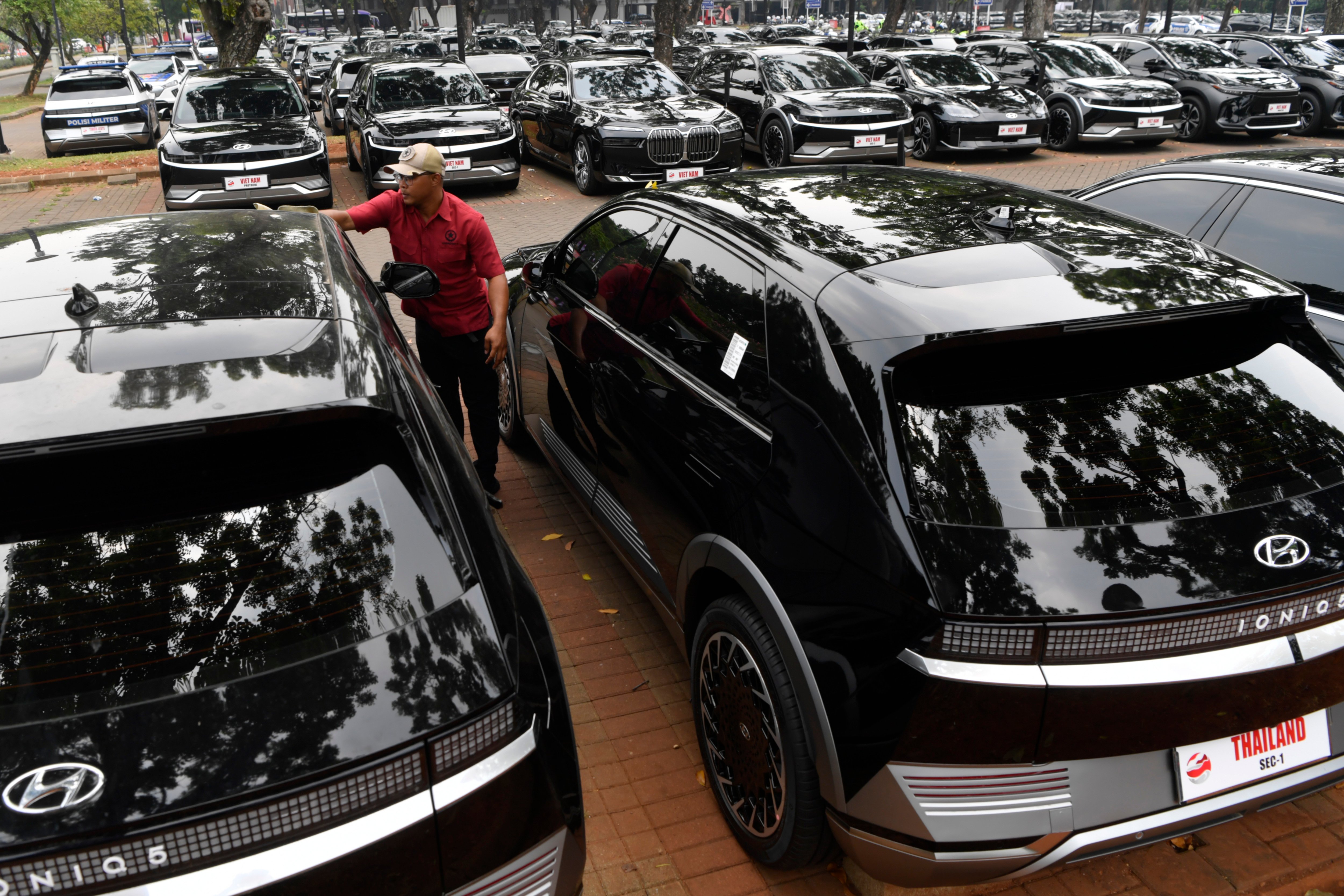 Petugas membersihkan kendaraan listrik delegasi KTT ASEAN di area Parkir Gelora Bung Karno, Jakarta.