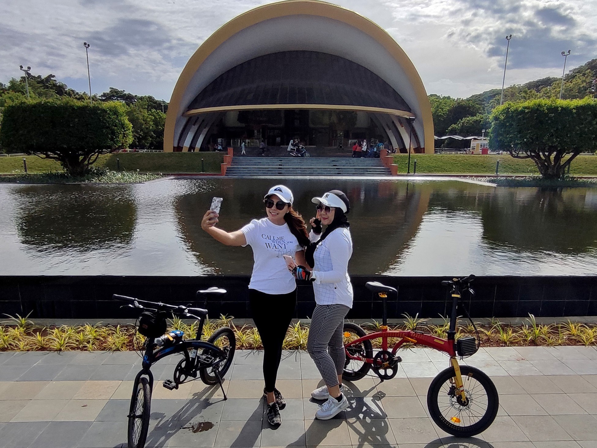 Pengunjung berswafoto di depan anjungan Keong Mas di Taman Mini Indonesia Indah (TMII), Jakarta, Minggu (20/11/2022).
