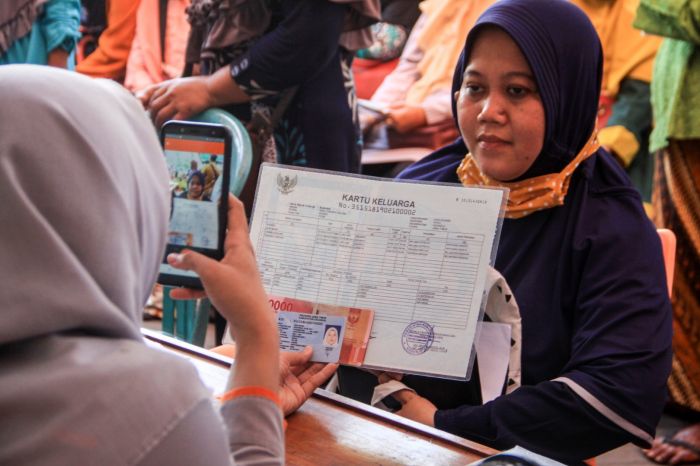 Petugas Pos Indonesia memofoto data dan warga yang menerima bansos dari Kemensos.