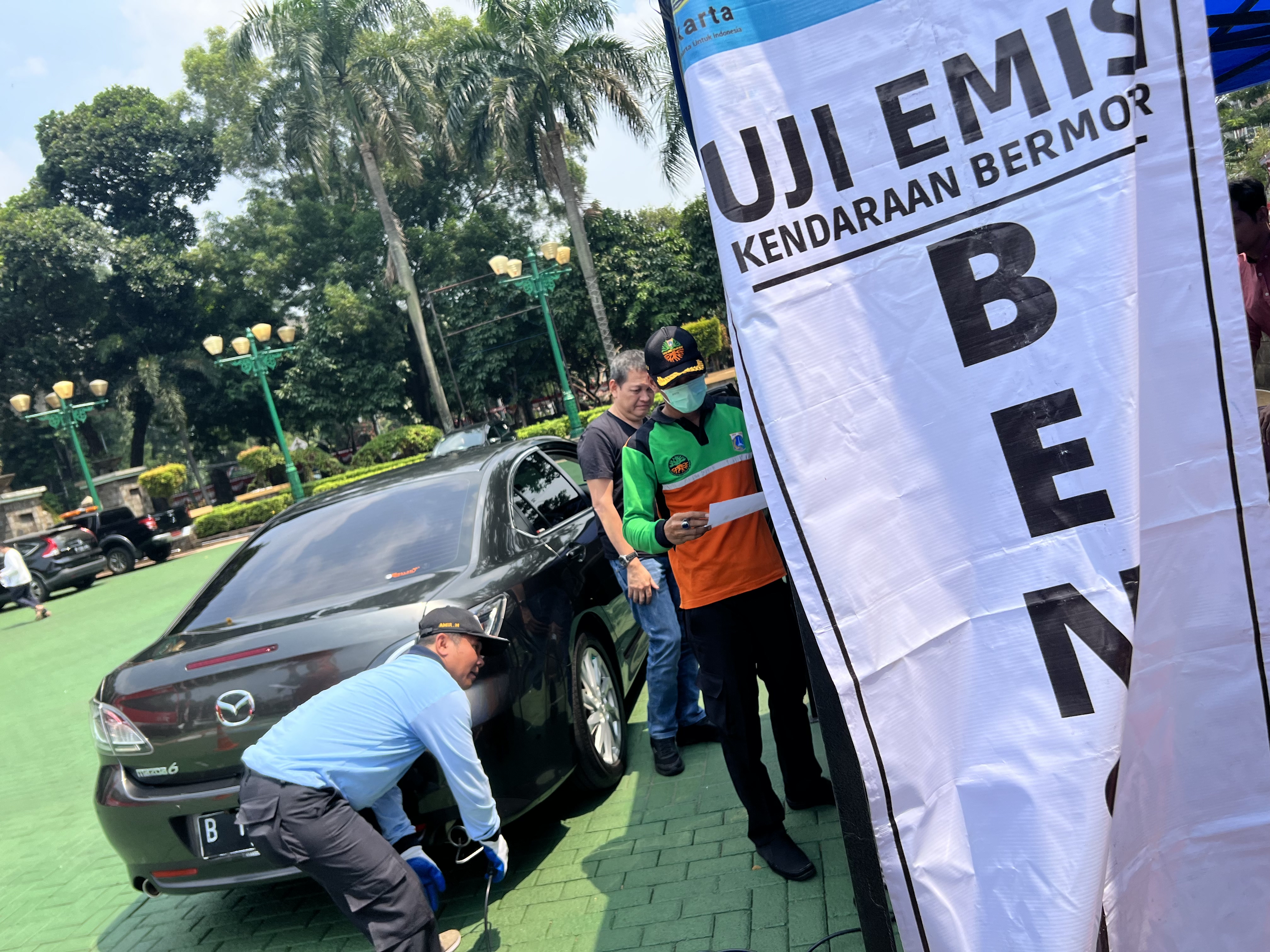 Petugas mengukur emisi gas buang kendaraan roda empat dan rosa dua di halaman kantor Wali Kota Jakarta Selatan.