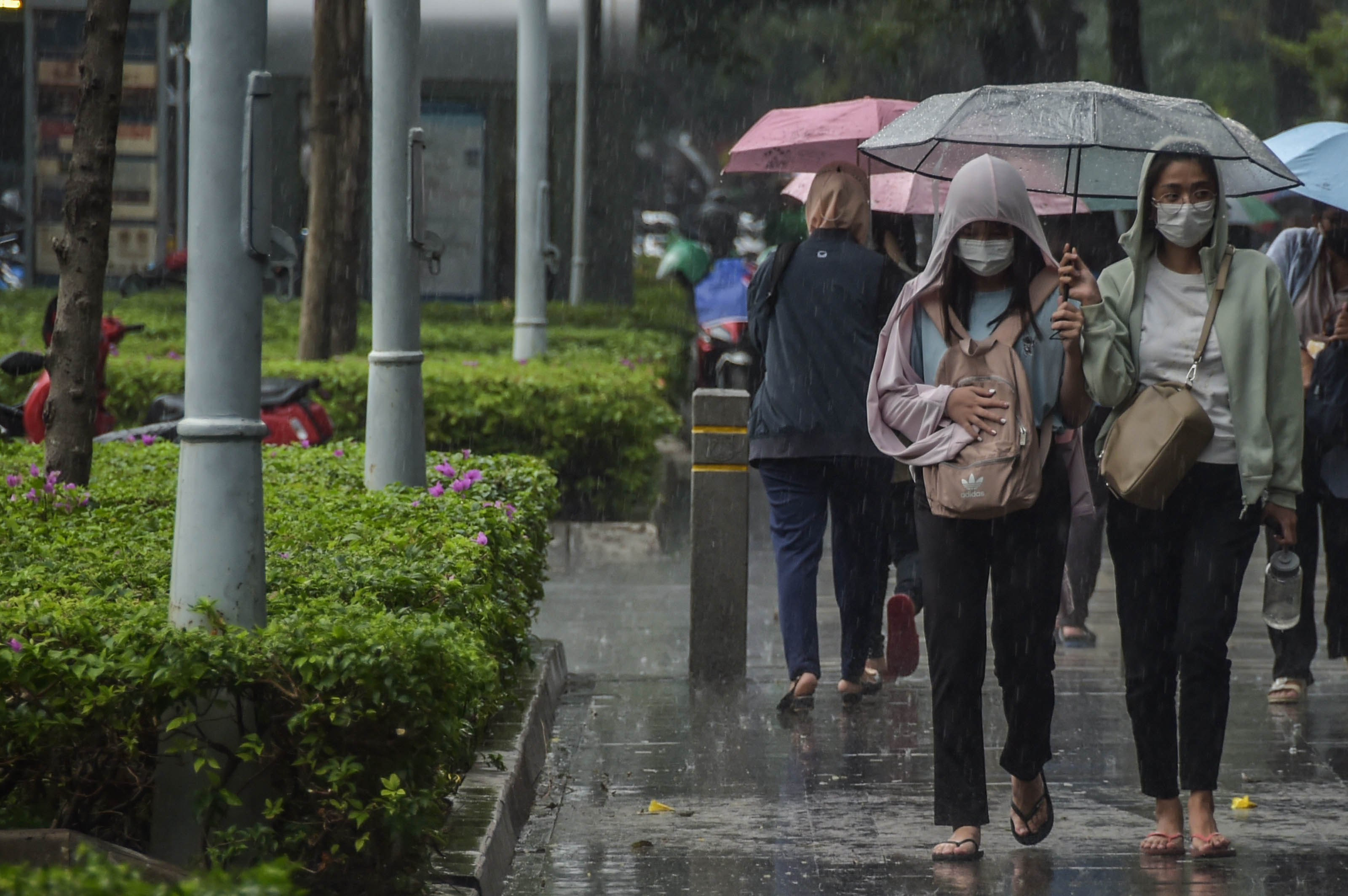 Sejumlah warga berjalan melewati hujan di Senayan, Jakarta (5/5).