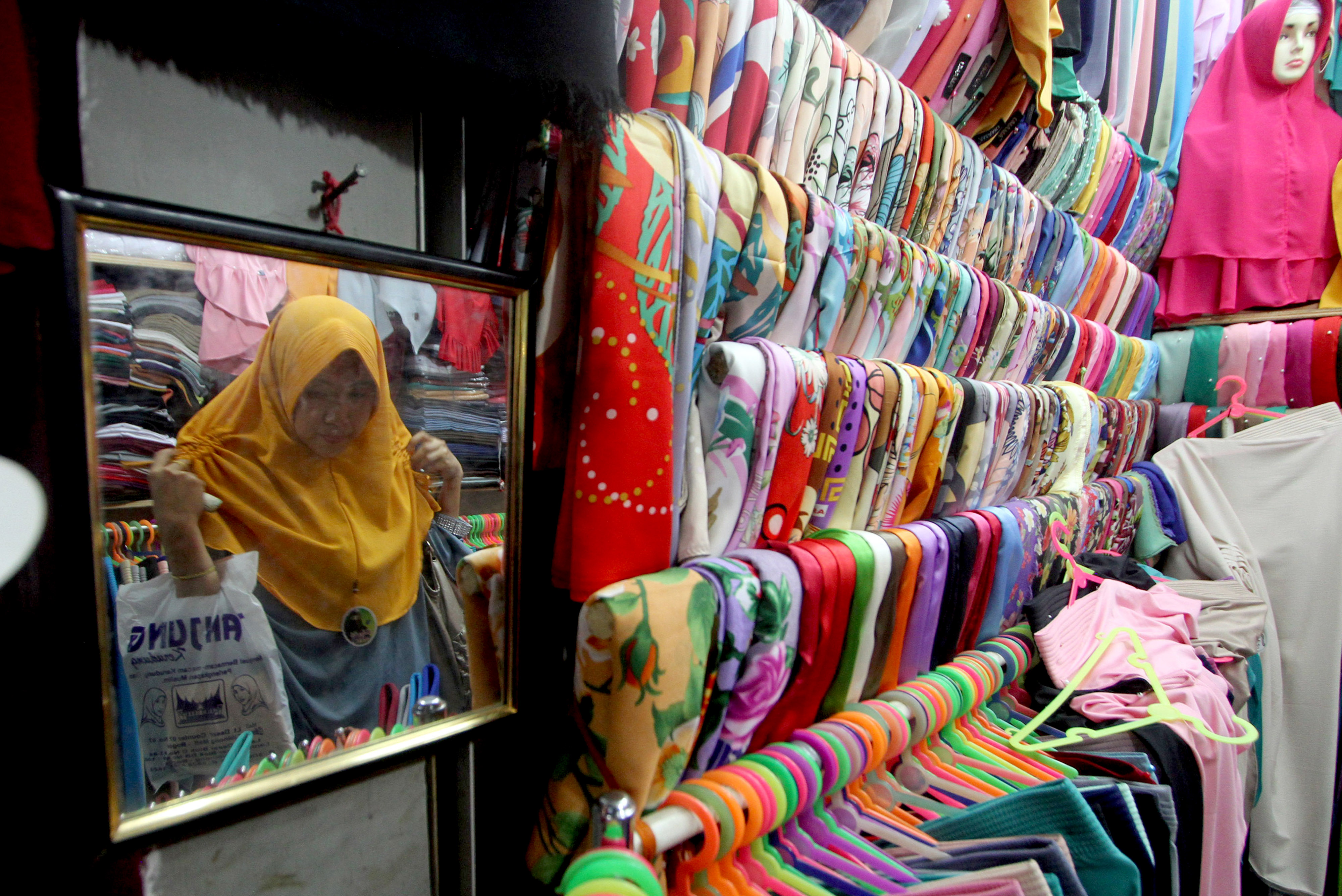 Calon pembeli memilih pakaian saat berbelanja di salah satu toko di Pasar Cibinong, Kabupaten Bogor, Jawa Barat, Jumat (25/5). 