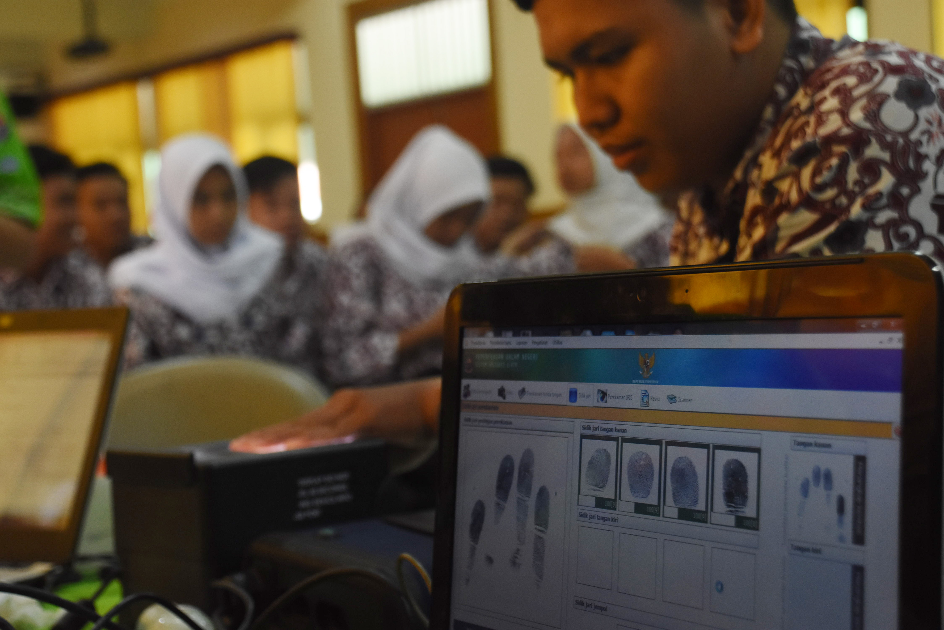 Petugas Suku Dinas Kependudukan dan Catatan Sipil Jakarta Selatan melakukan perekaman data sidik jari untuk KTP elektronik.