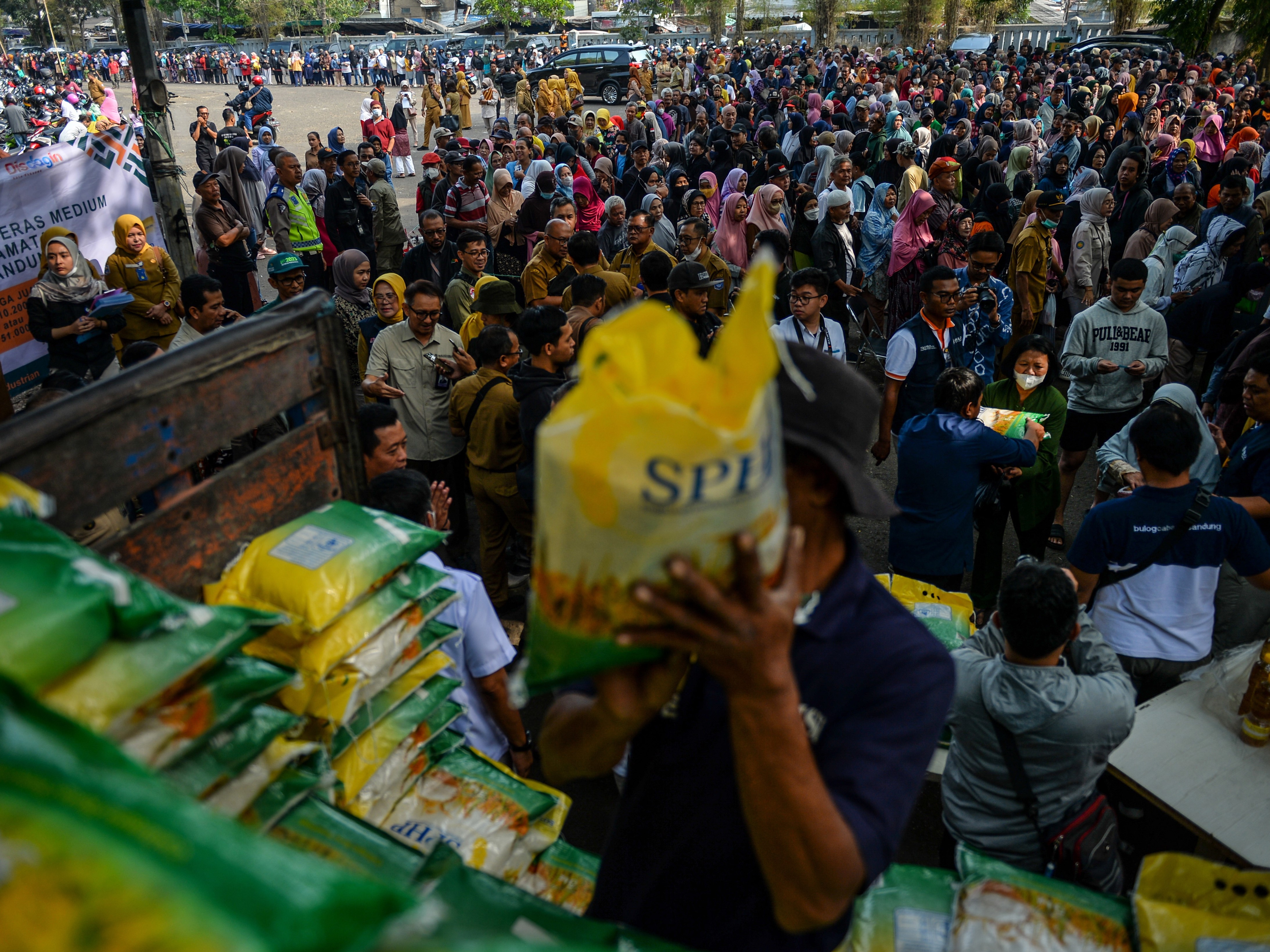 Petugas menurunkan beras medium saat operasi pasar murah di Monumen Perjuangan, Bandung, Jawa Barat, Selasa (19/9/2023).