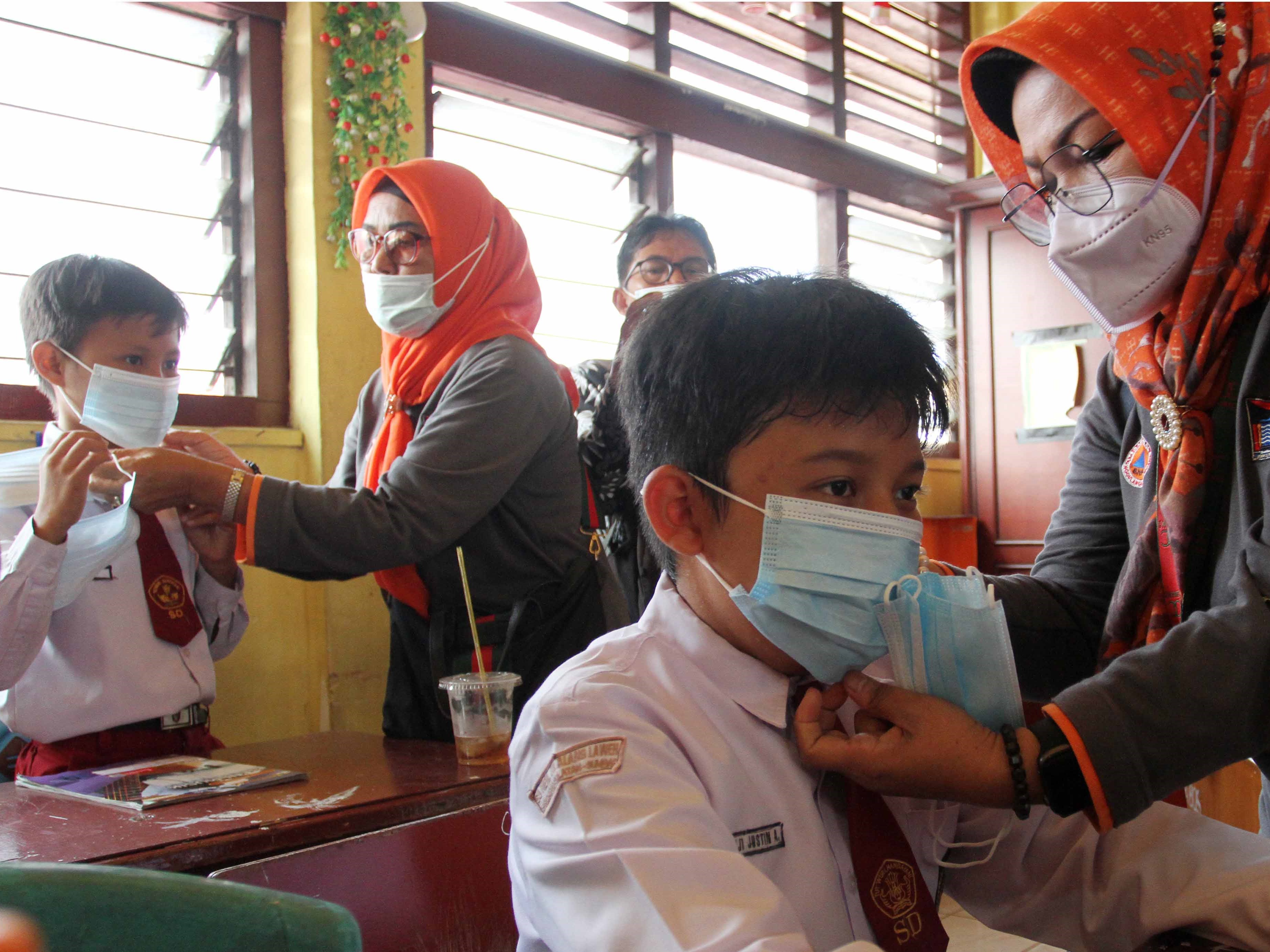 KSB Srikandi Kota Padang memasangkan masker kepada murid Sekolah Dasar Negeri (SDN) 01 Alang Laweh di Padang, Sumatra Barat, Senin (18/9).