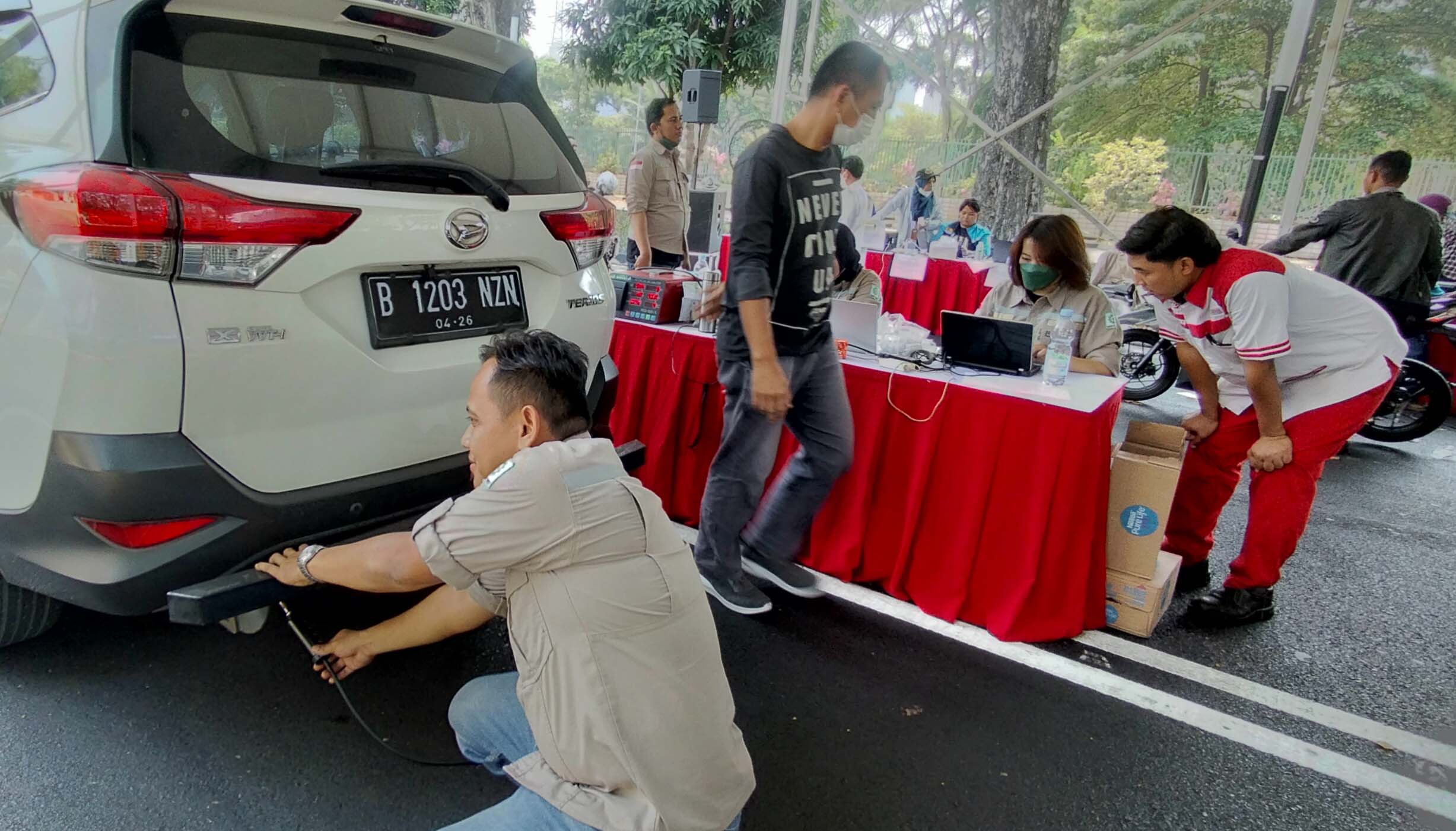 Petugas Uji Emisi mwlakukan pengecekan terhadap kendaraan bermotor