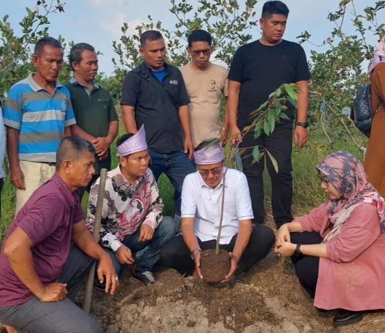H Ayep Zaki (berbaju putih) menanam bibit pohon durian jenis Musangking.