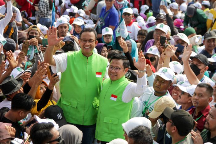 Anies Baswedan (kiri) dan Muhaimin Iskandar menyapa warga di Sidoarjo, Jawa Timur, Minggu (15/10).