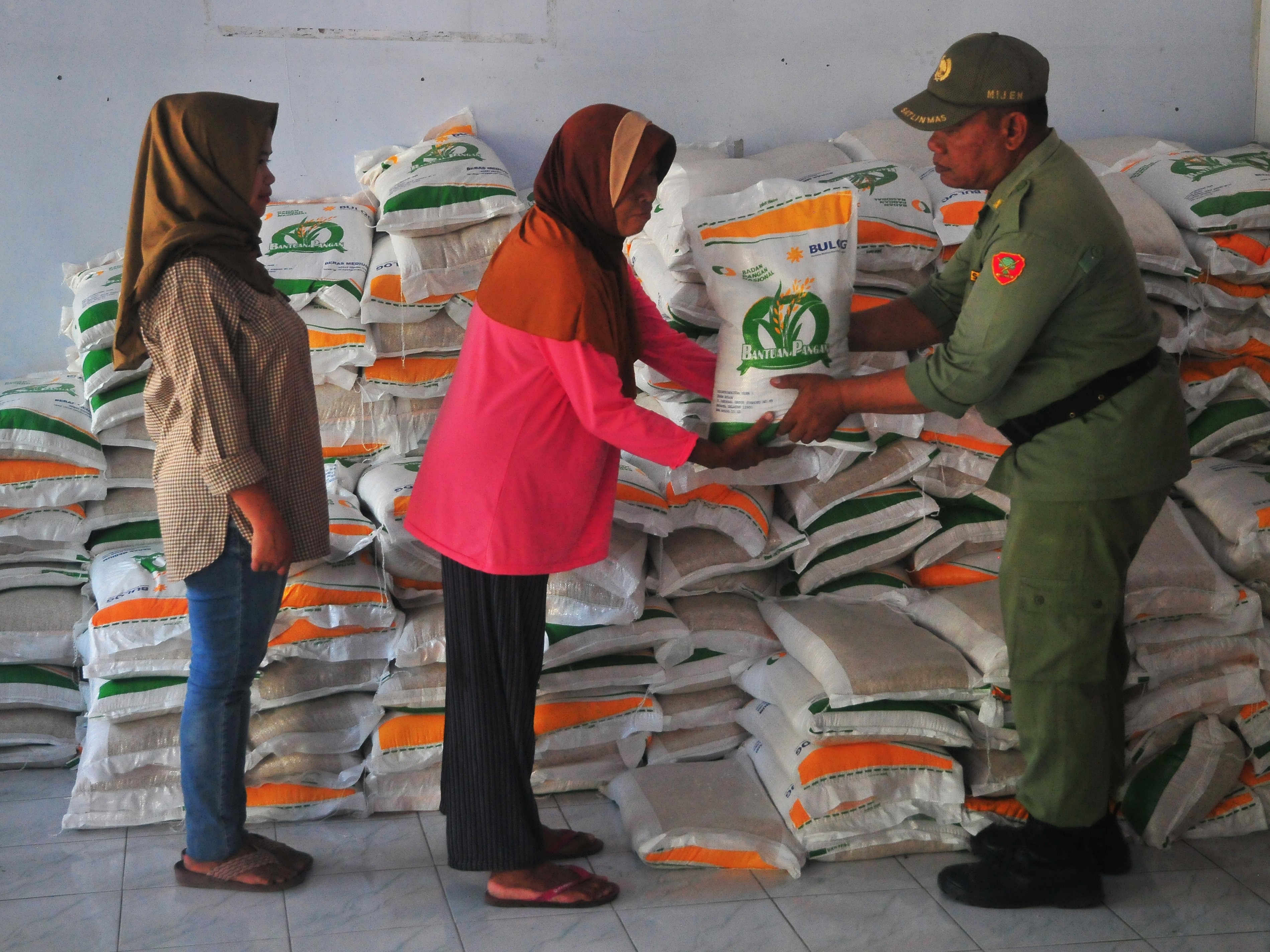 Warga menerima beras saat penyaluran bantuan pangan cadangan beras pemerintah di Desa Mijen, Kaliwungu, Kudus, Jateng, Rabu (27/9/2023).