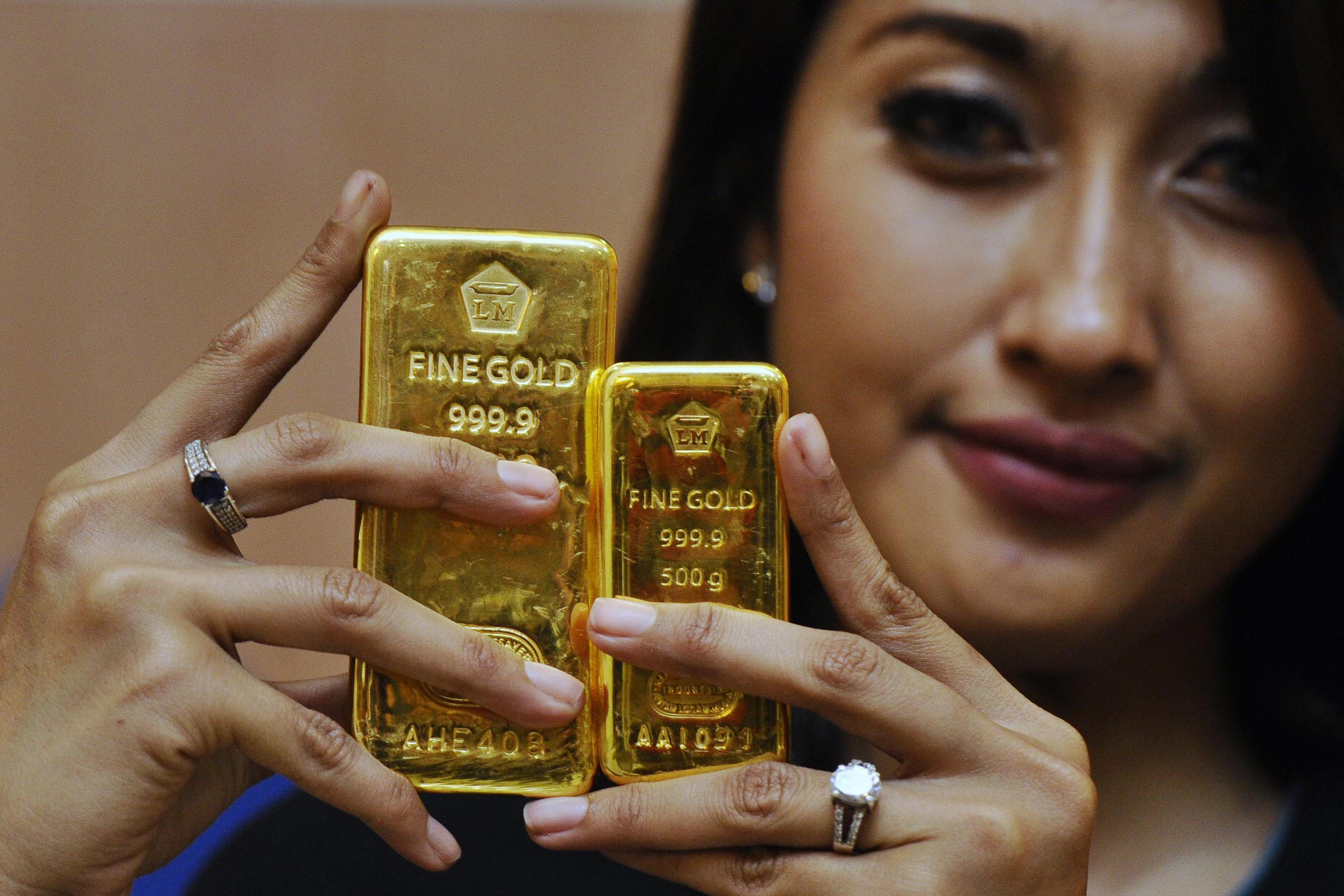 Seorang petugas memperlihatkan emas batangan produksi PT Antam di Jakarta, Senin (19/1/2015). 