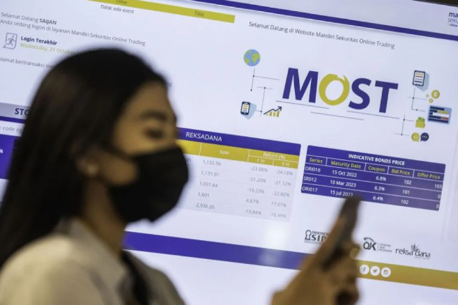 Karyawan beraktivitas di depan tampilan layar dari situs Mandiri Online Securities Trading (MOST).