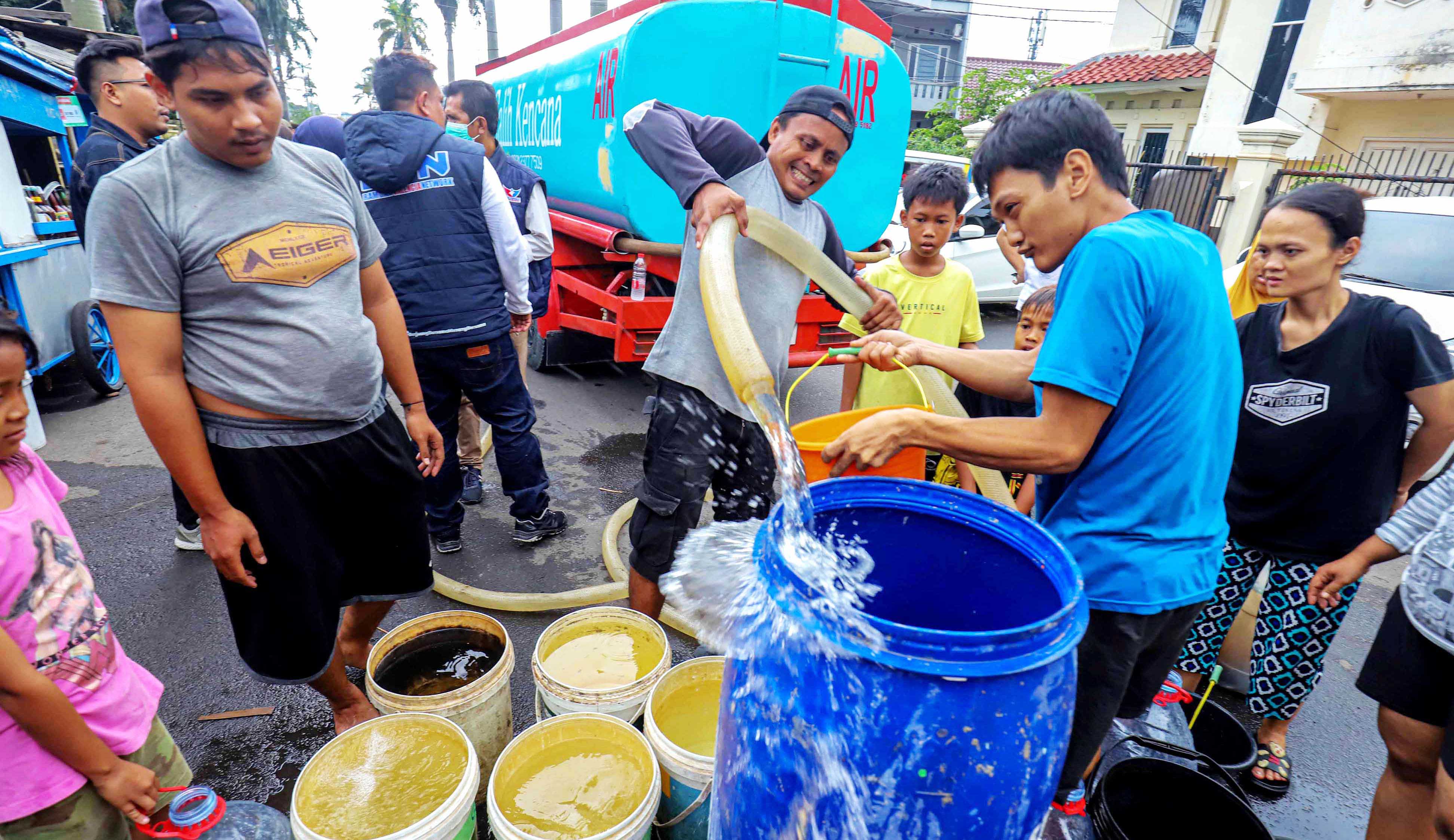 Warga antre untuk mendapatkan bantuan air bersih