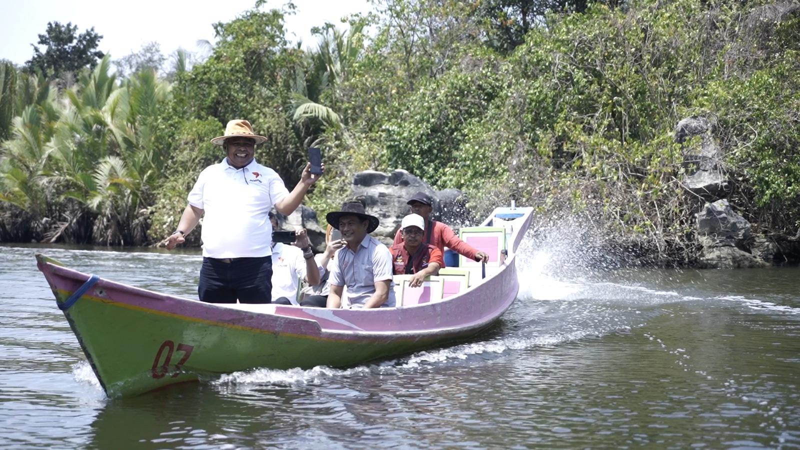 Juru bayar Pos Indonesia menaiki perahu menuju Dusun Rammang-rammang, Kabupaten Maros, Sulawesi Selatan.