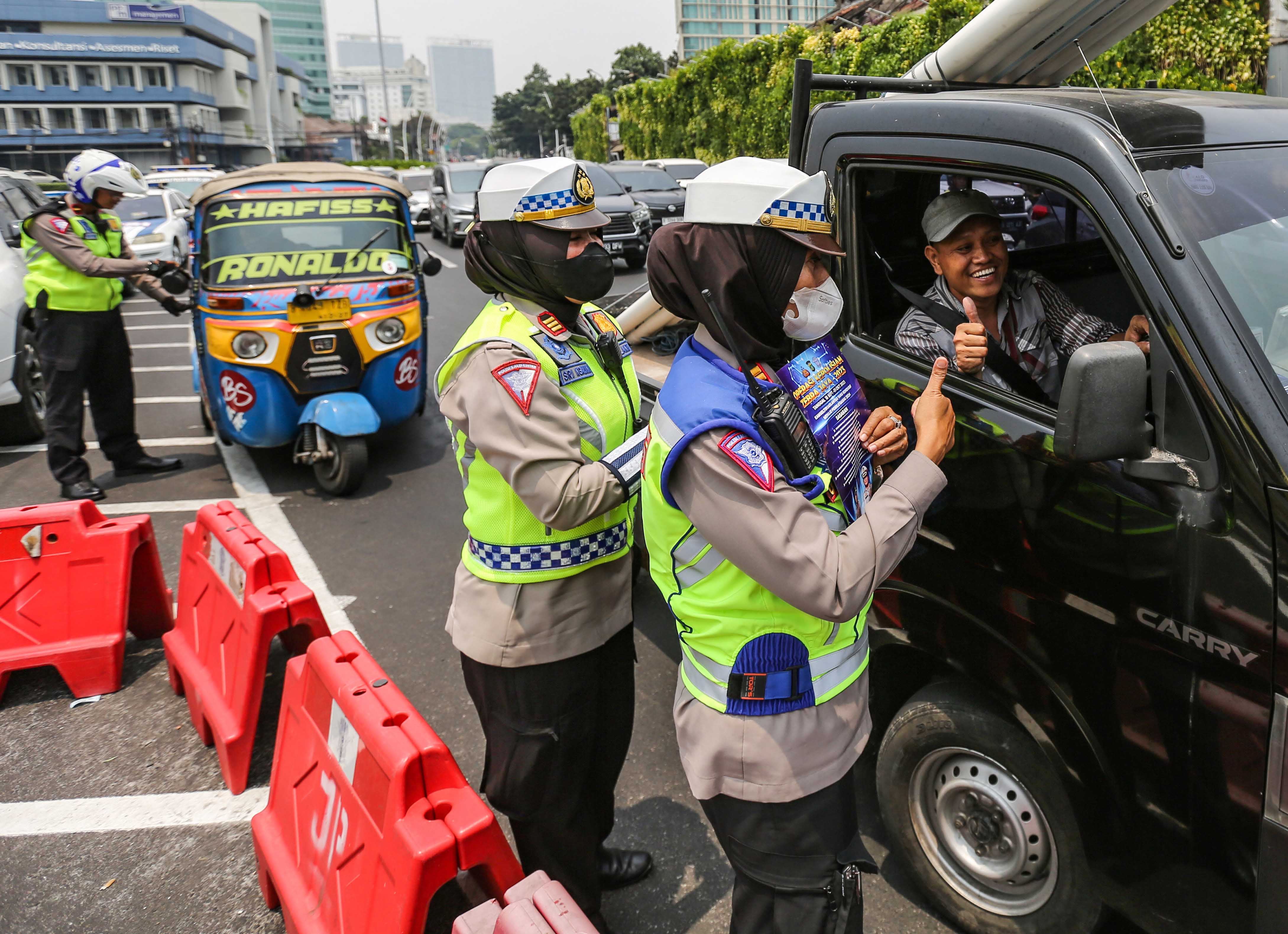 Petugas Kepolisian memberikan sosialisasi Operasi Zebra Jaya 2023 di Tugu Tani, Jakarta, Senin (18/9).