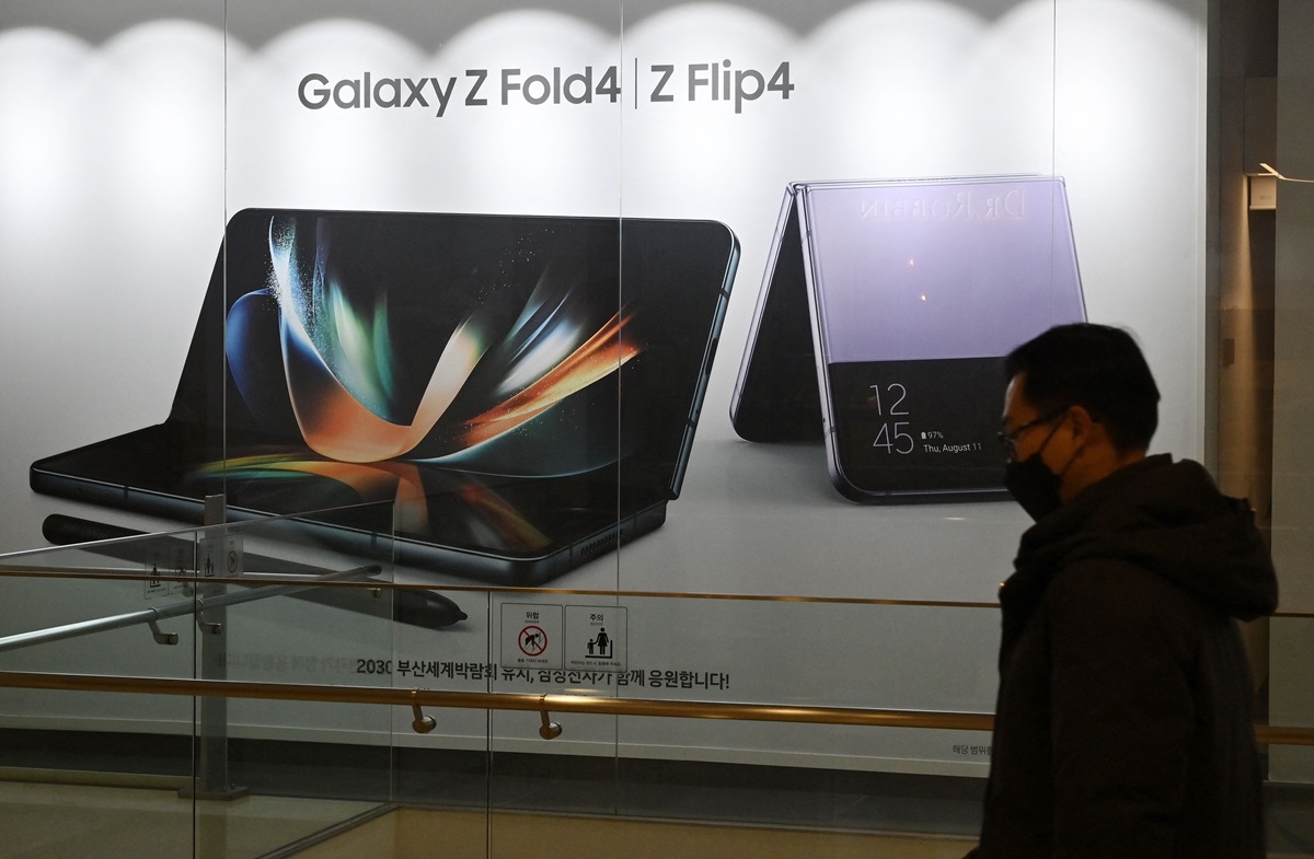 Ilustrasi--Seorang pria berjalan melewati reklame yang menampilkan ponsel lipat Samsung Galaxy Z Fold dan Galaxy Z Flip