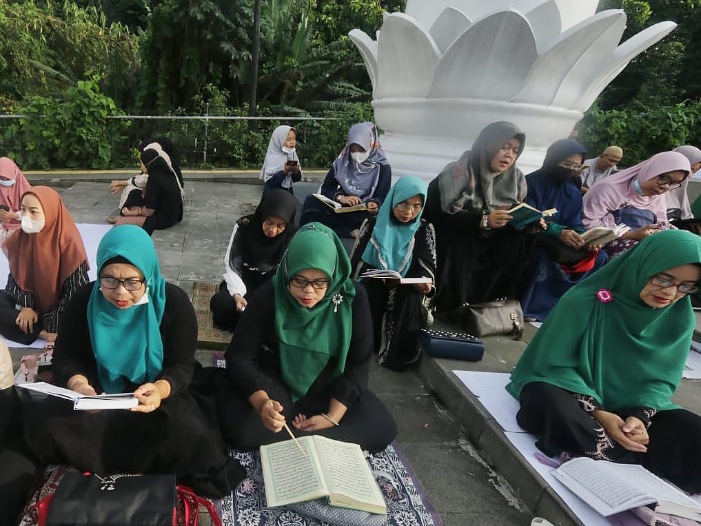 Ibu-ibu membaca Al-Qur'an saat mengikuti Bogor Ngaos Alquran di Lawang Salapan, Kota Bogor, Jawa Barat, Minggu (24/4). 