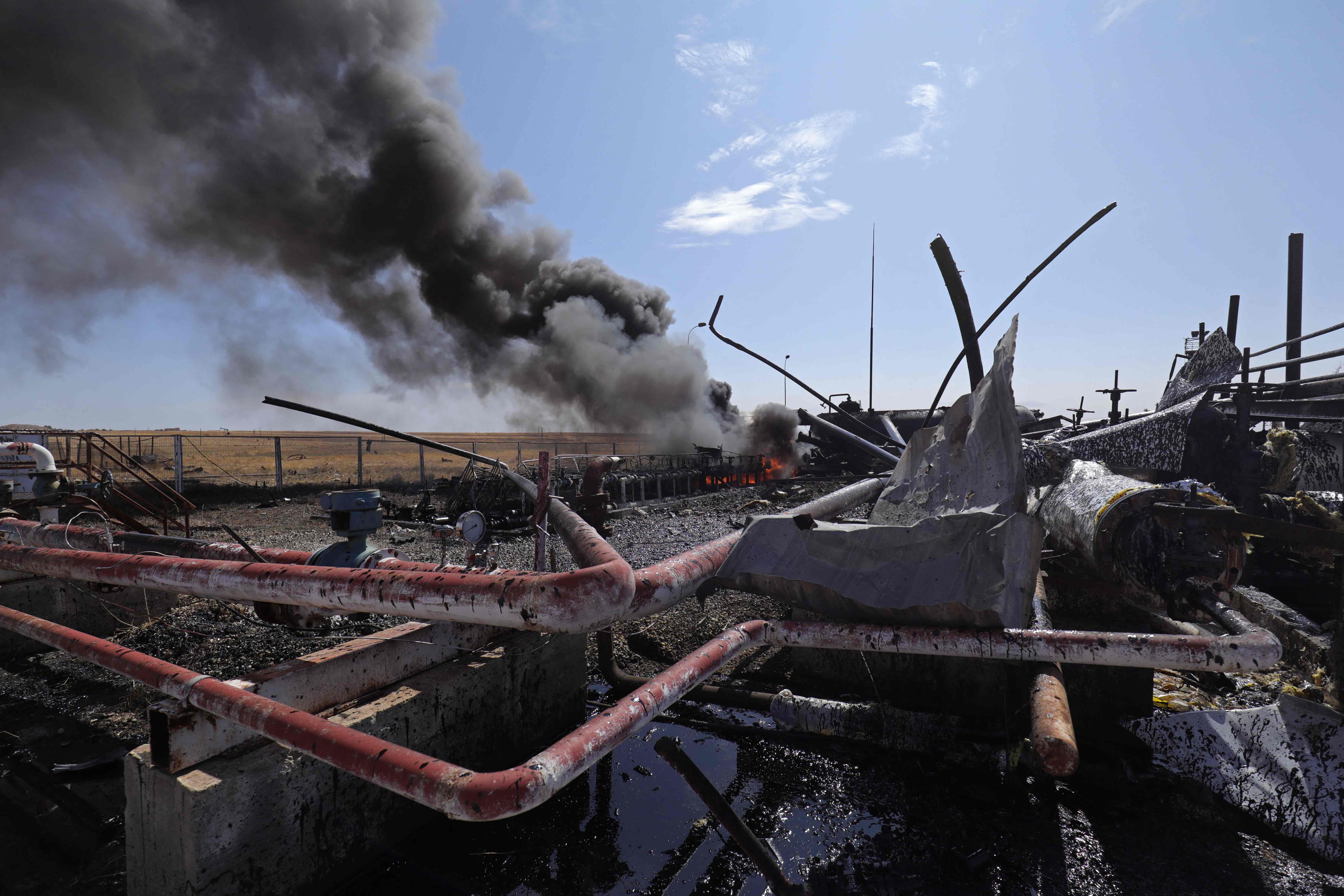 Asap mengepul dari fasilitas minyak Babasi di pedesaan al-Qahtaniya yang dikuasai Kurdi di Suriah pada 6 Okto