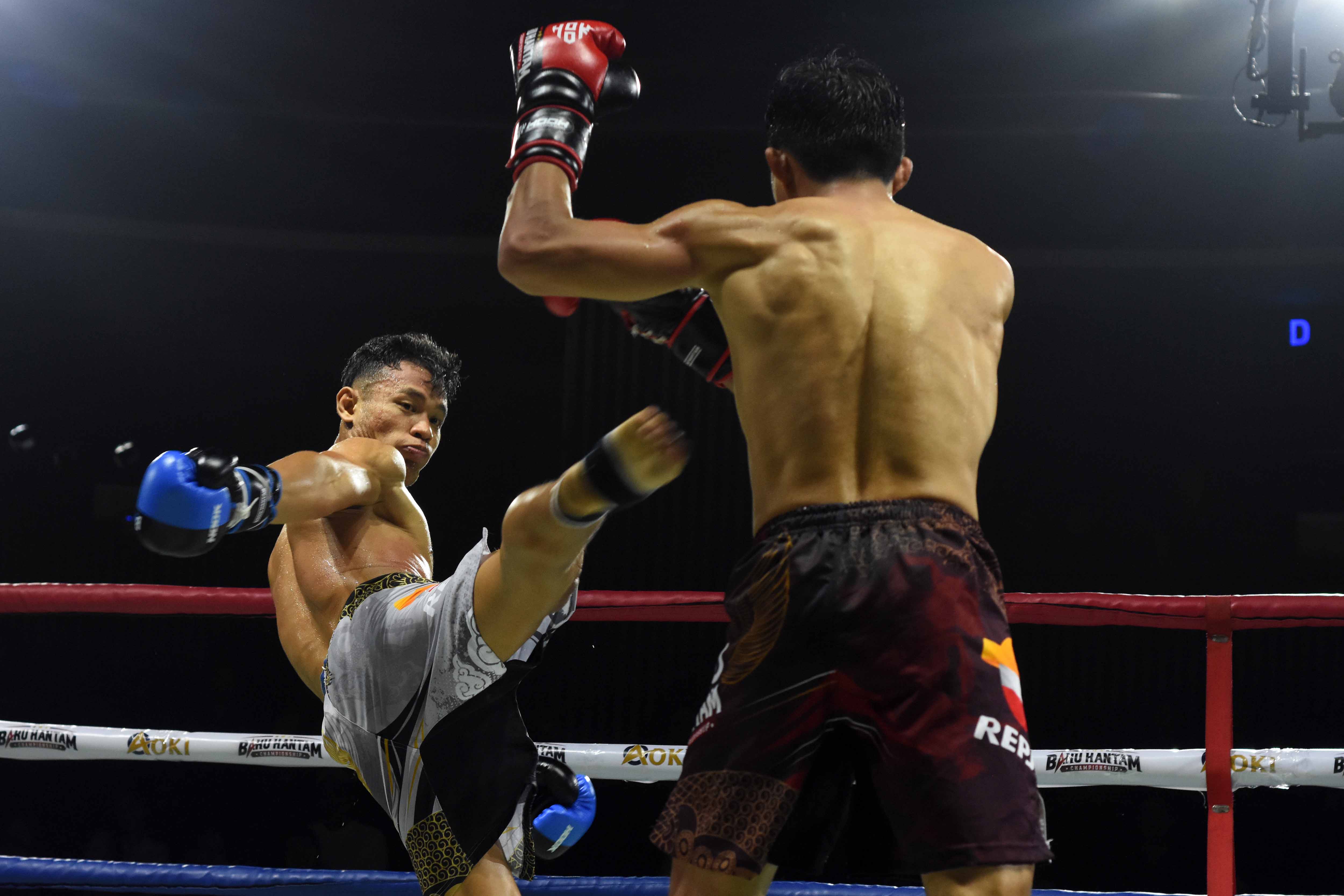 Petarung Brian Lawitan (kiri) mendaratkan tendangan kearah lawannya petarung Fahri Alamsyah pada pertandingan Baku Hantam Championship.