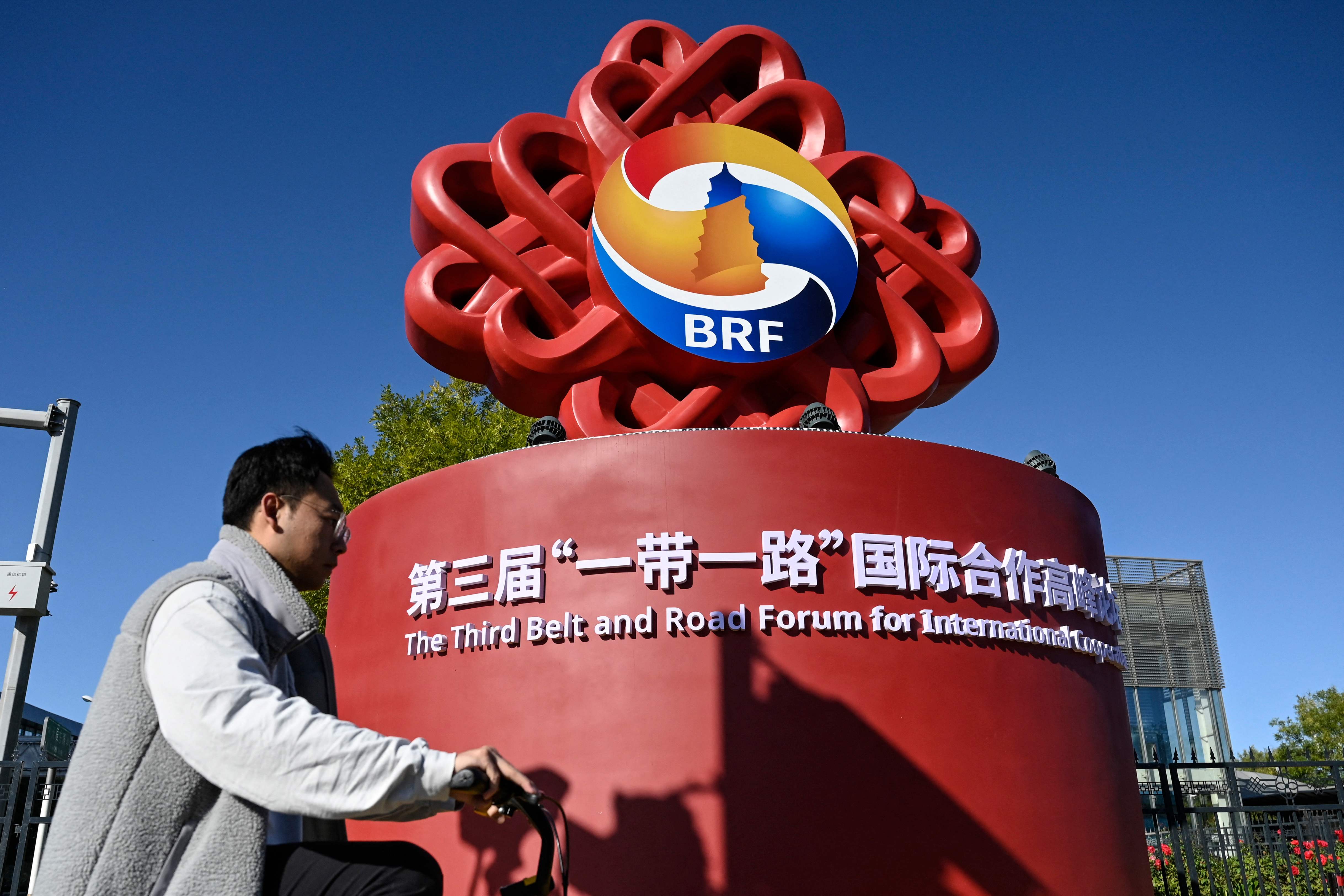 Warga melintas di depan logo Belt and Road Forum di Beijing, 15 Oktober 2023.