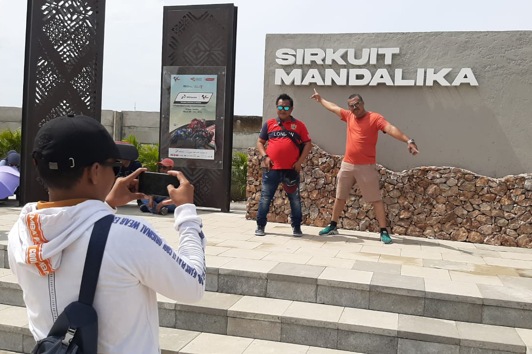Penonton mengambil foto di tugu Sirkuit Mandalika, Lombok, Nusa Tenggara Barat, Minggu (20/3/2022).
