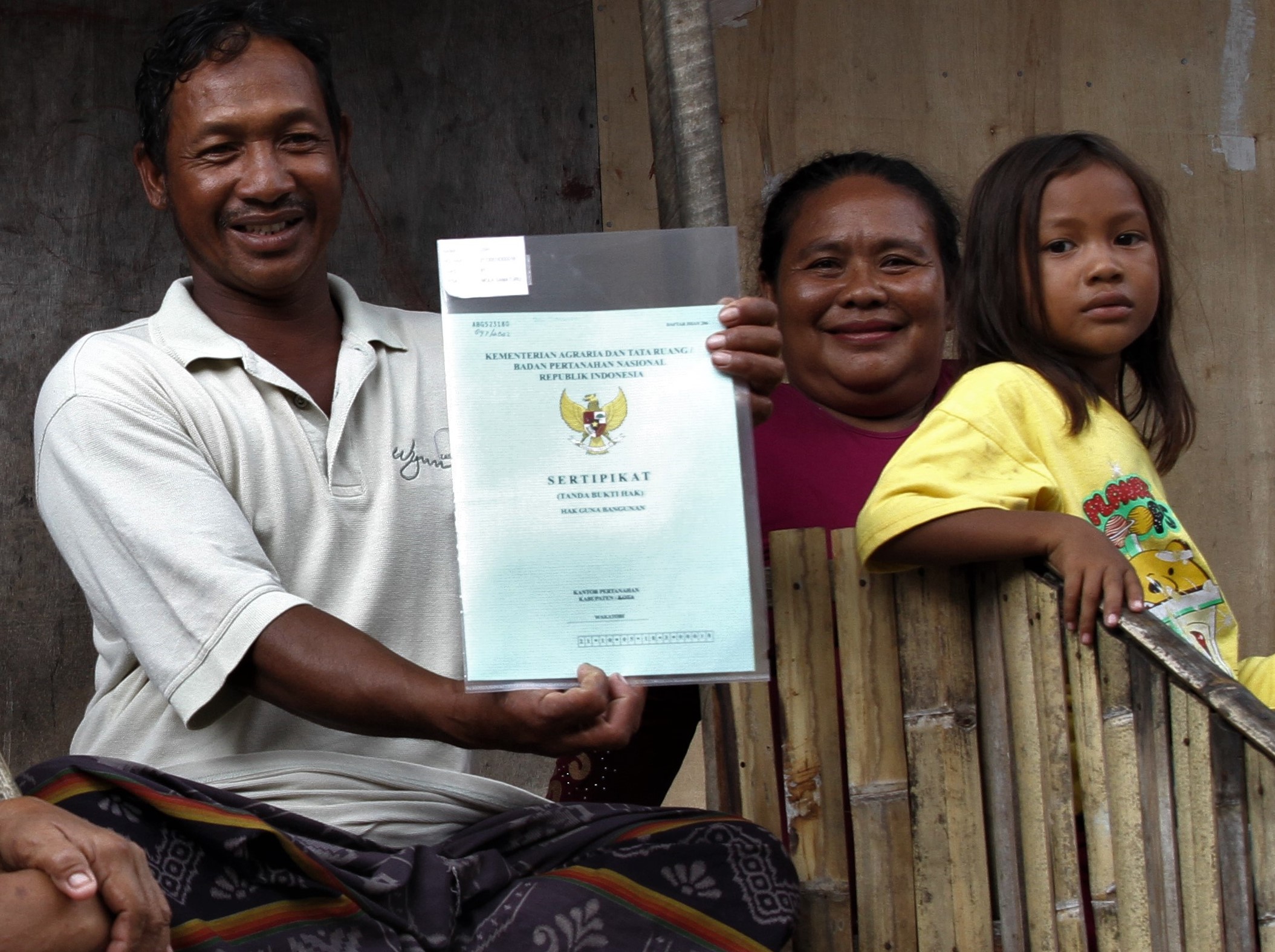 Warga menunjukkan sertifikat tanah yang diberikan secara gratis oleh Presiden Joko Widodo