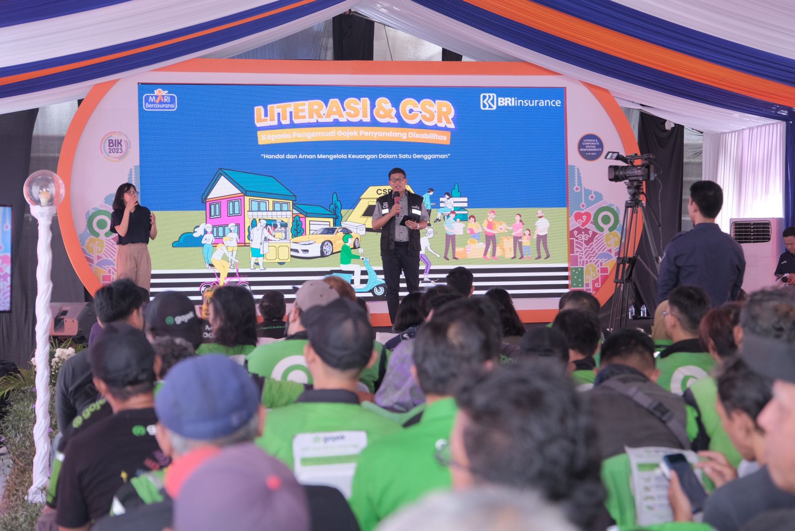  BRI Insurance berikan literasi keuangan dan melakukan penyerahan bantuan CSR kepada pengemudi ojek online disabilitas.