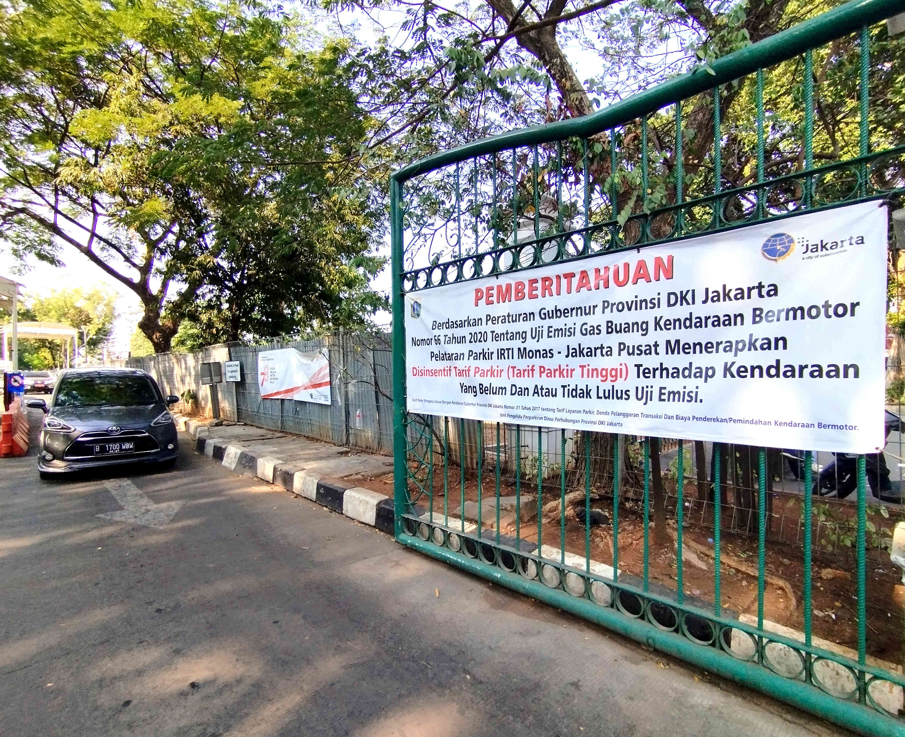 Pemberitahuan mengenai penerapan tarif parkir tertinggi bagi kendaraan yang tidak lulus uji emisi di IRTI Jakarta.